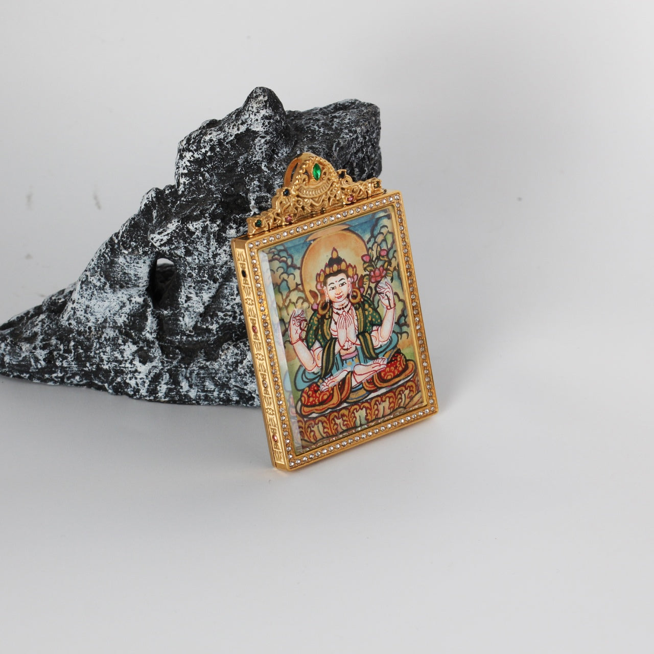 The Nepal Elegant Four-Armed Avalokiteshvara Thangka pendant displayed as a sacred amulet for compassion and protection, embodying Tibetan Buddhist tradition.
