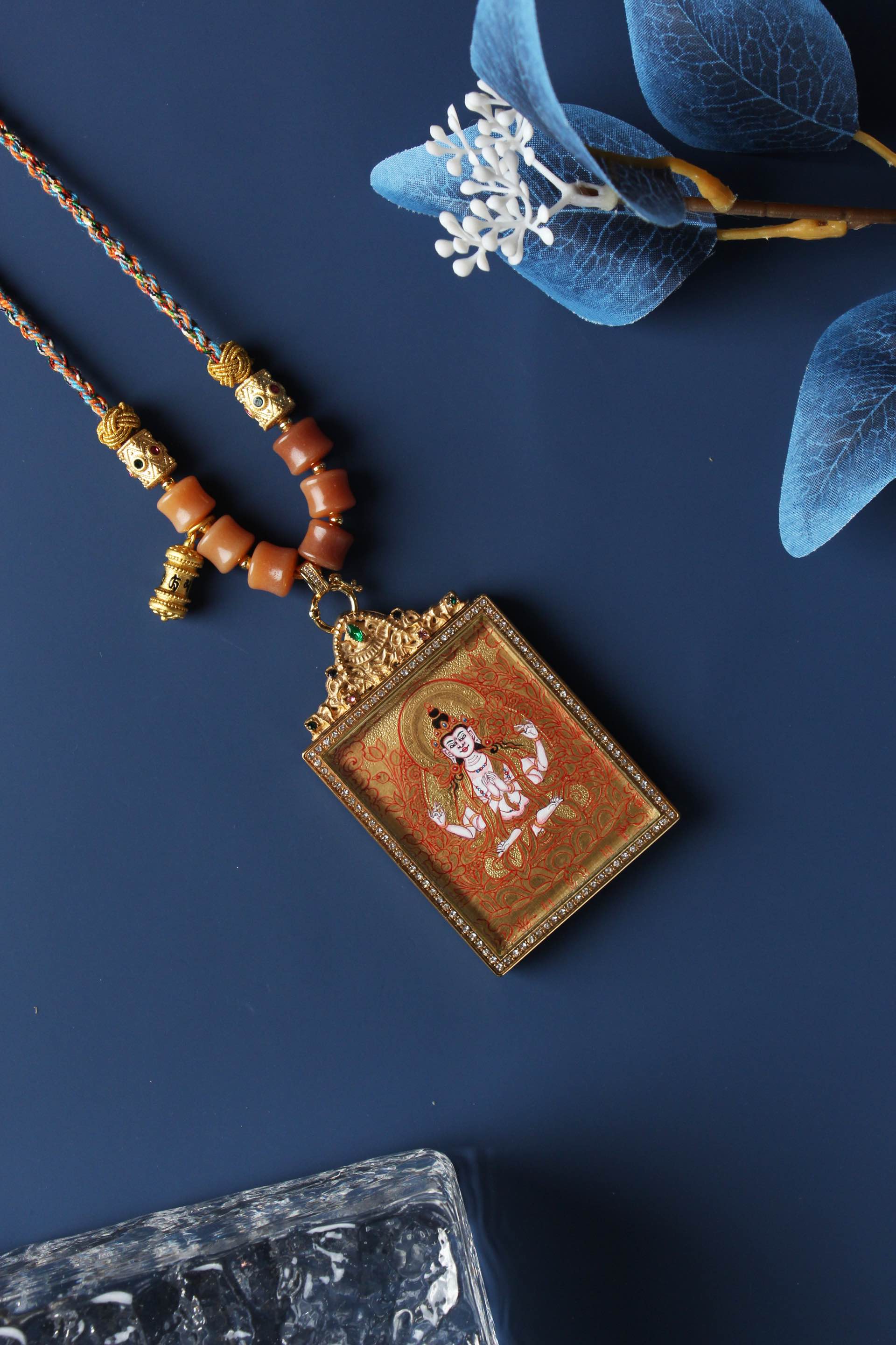  A 4x5cm hand-painted Rebgong Four-Armed Avalokiteshvara Thangka pendant featuring the Bodhisattva of Compassion, encased in titanium steel, representing compassion and mercy in Tibetan Buddhist tradition.

