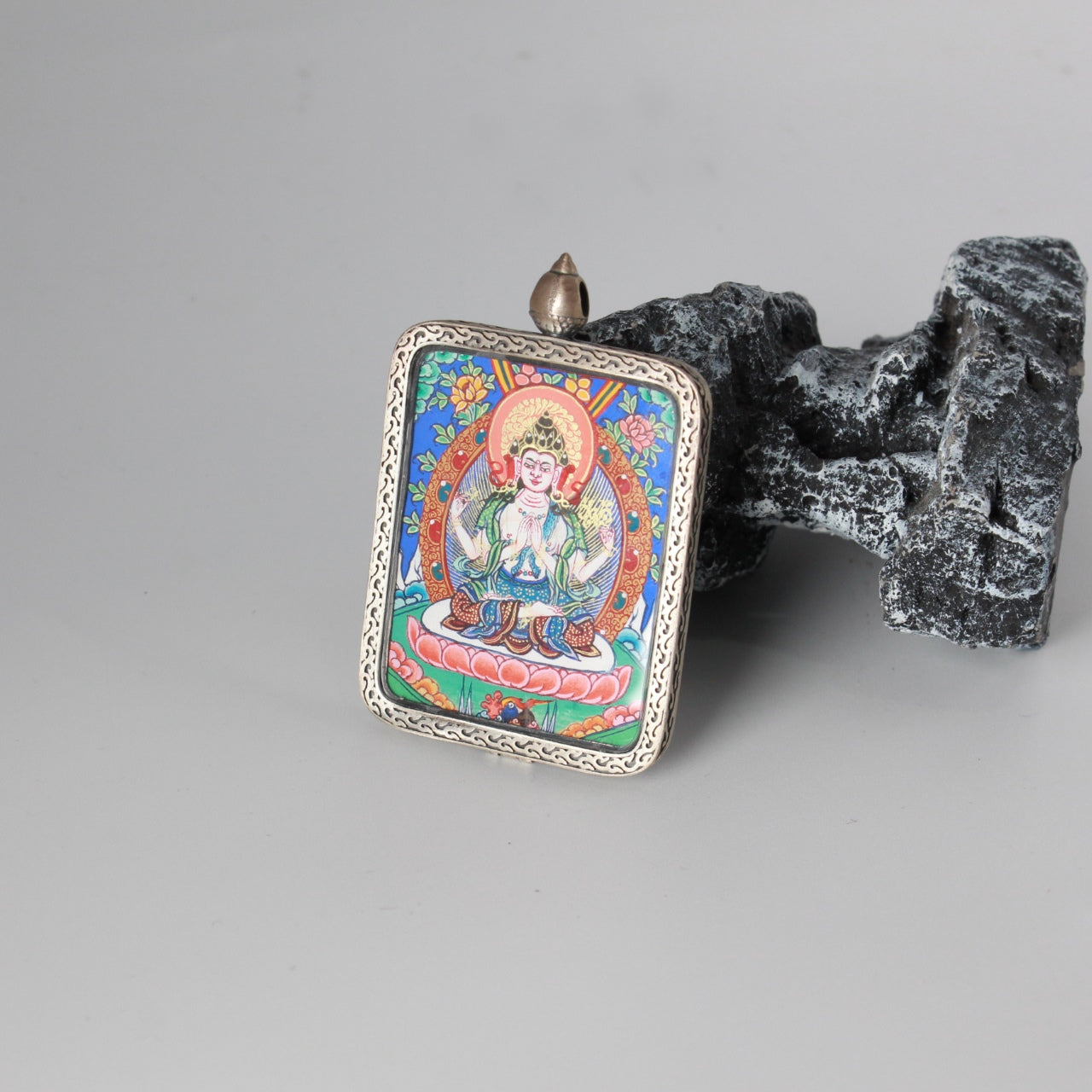 Hand-painted Rebgong Four-Armed Avalokiteshvara Thangka pendant featuring the Embodiment of Great Compassion, Dunhuang silver case, representing compassion and peace in Tibetan Buddhist tradition.
