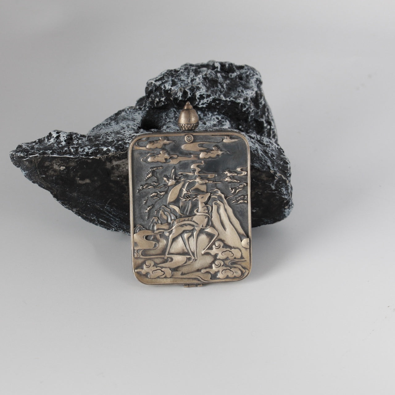 The Rebgong Four-Armed Avalokiteshvara Thangka pendant displayed as a sacred amulet for compassion and peace, embodying Tibetan Buddhist tradition.
