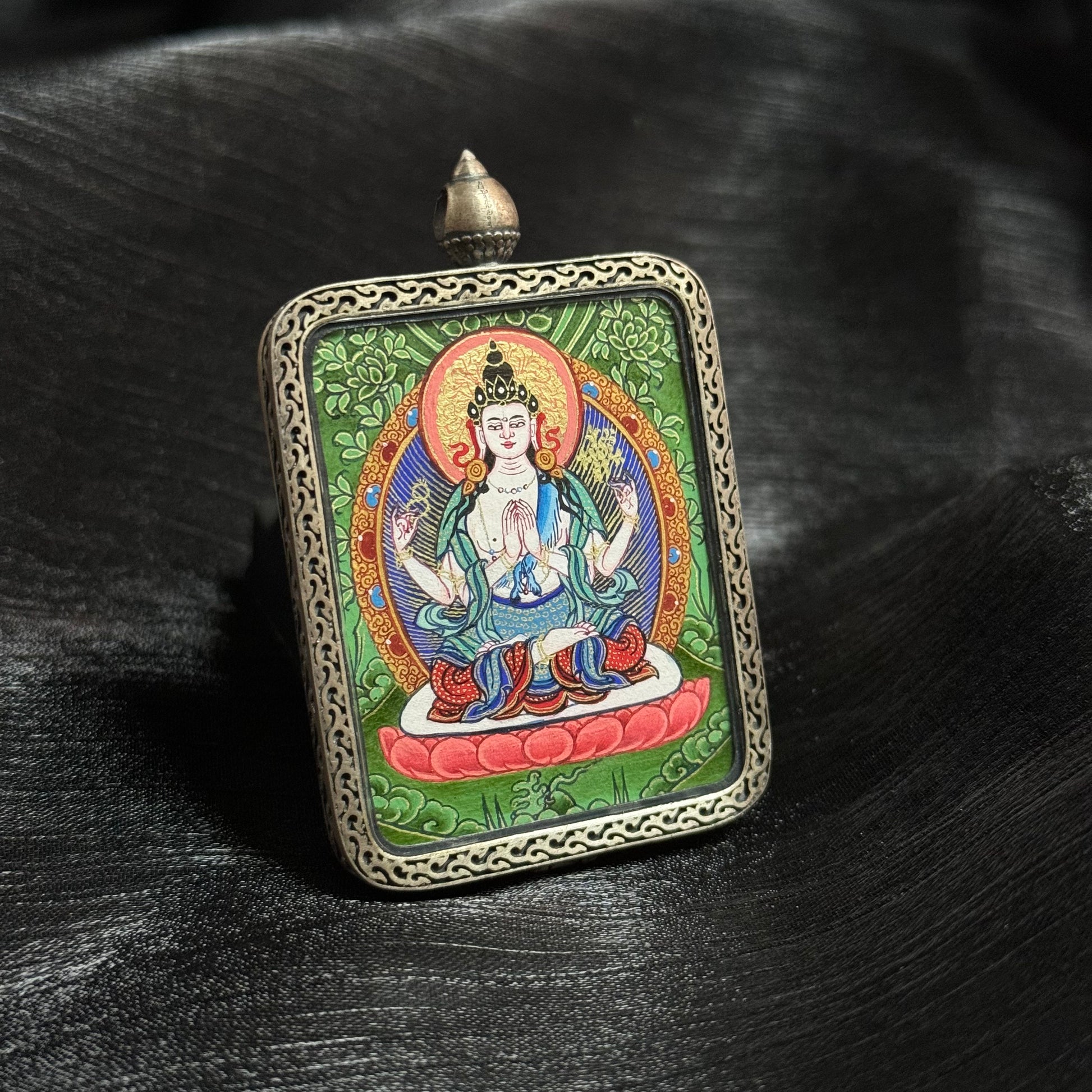  Detailed view of the presentation and casing for the Four-Armed Avalokiteshvara Cuiying Thangka pendant, symbolising compassion and tradition in Buddhist practice.

