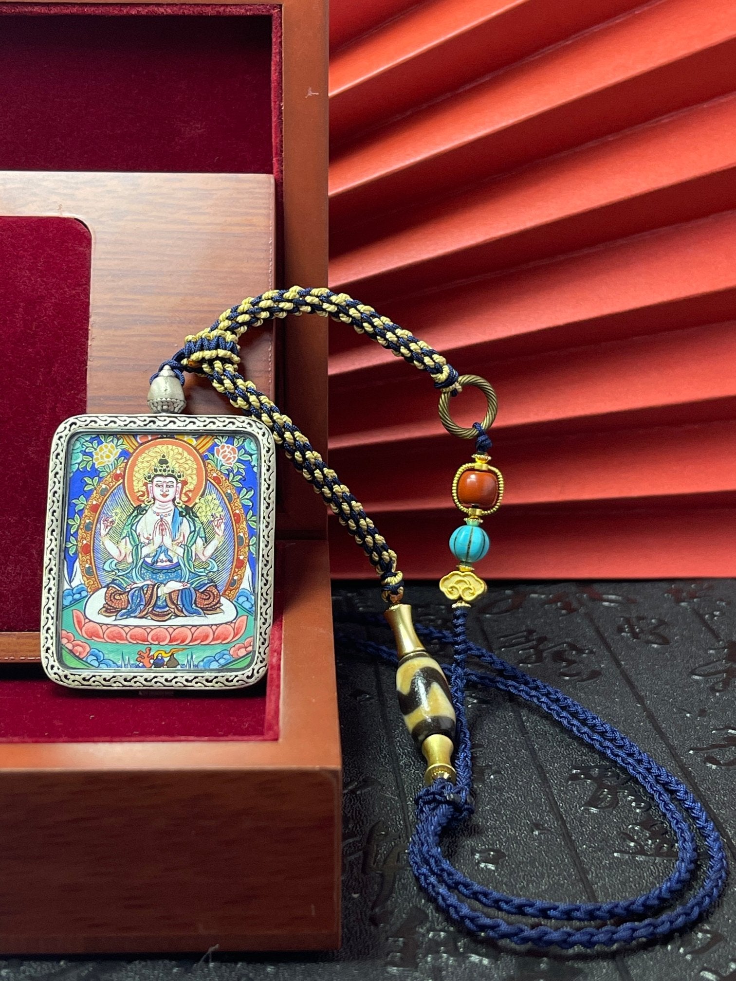 Close-up detail of the Rekong Four-Armed Avalokiteshvara Thangka showing hand-painted mineral pigments, showcasing the masterful artistry and colour stable for a hundred years.