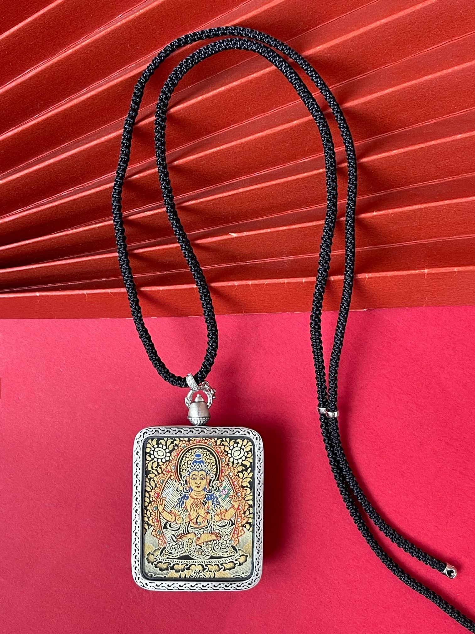  Hand-painted Rekong Black Gold Four-Armed Avalokiteshvara (四臂观音) Thangka pendant 3.5x4.5cm with deer relief silver casing featuring the Bodhisattva of Compassion, representing compassion and family harmony in Buddhist tradition.
