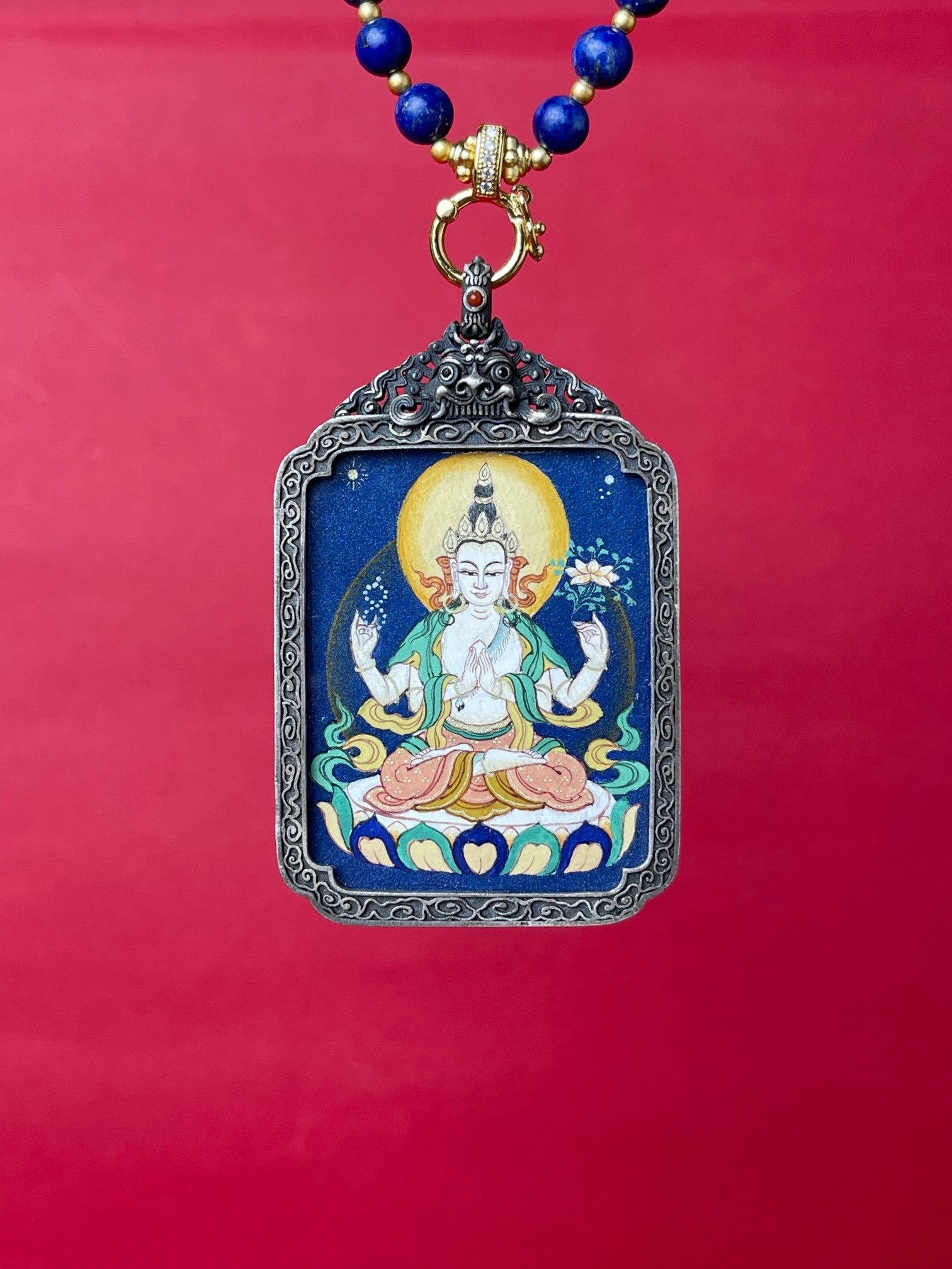  Detailed view of the refined silver casing for the Four-Armed Avalokiteshvara Thangka pendant, symbolising compassion and tradition in Buddhist practice.

