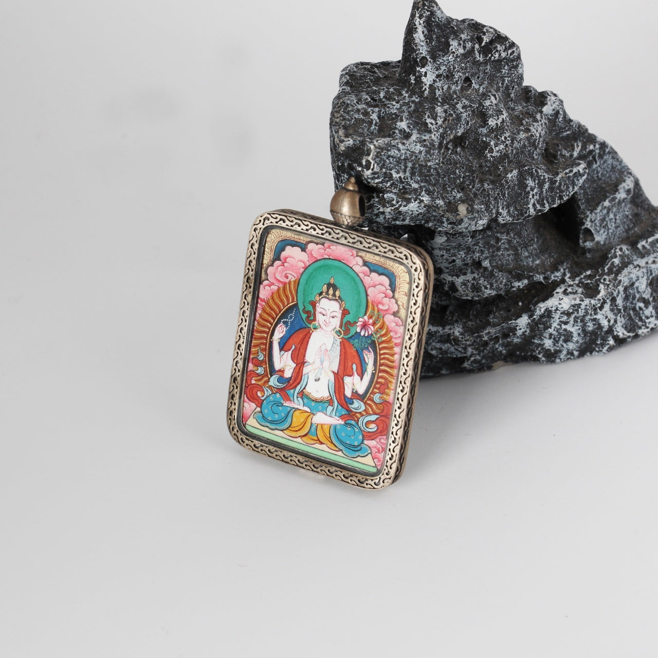  The Tibet Red Cloud Four-Armed Avalokiteshvara Thangka pendant displayed as a sacred amulet for compassion and protection, embodying Tibetan Buddhist tradition.


