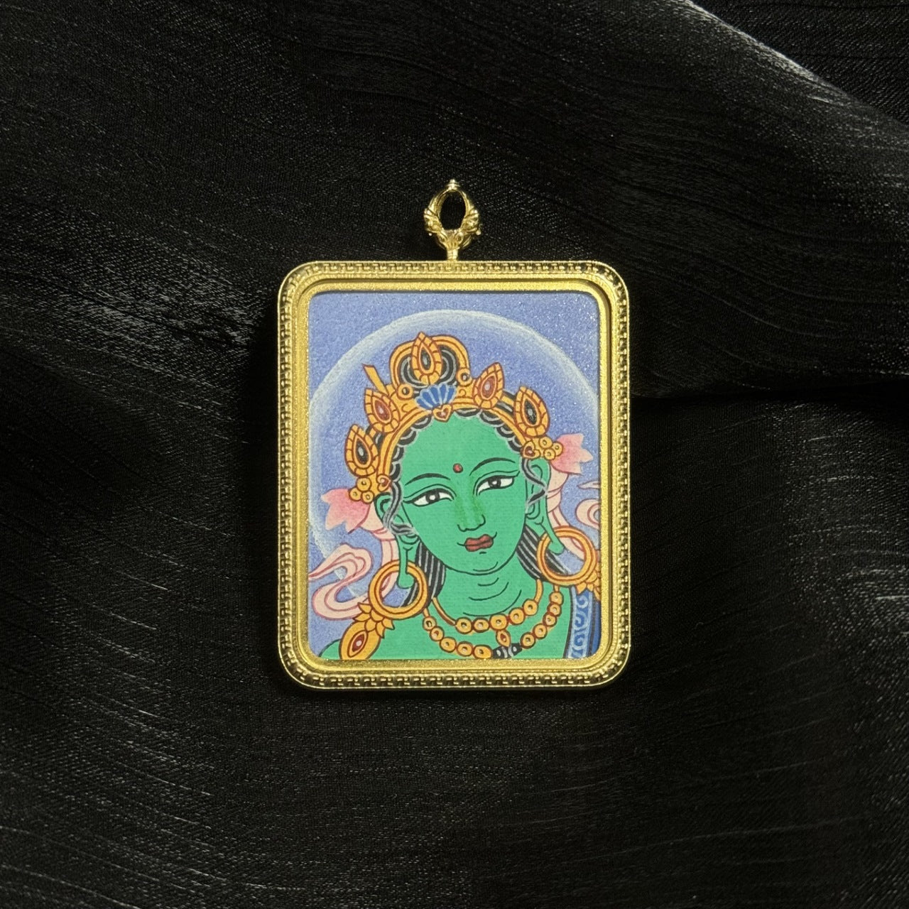  A 4x5cm hand-painted Nepal Bold Green Tara Buddha Head Thangka pendant featuring the Liberator from Eight Dangers, representing compassion and protection in Buddhist tradition.

