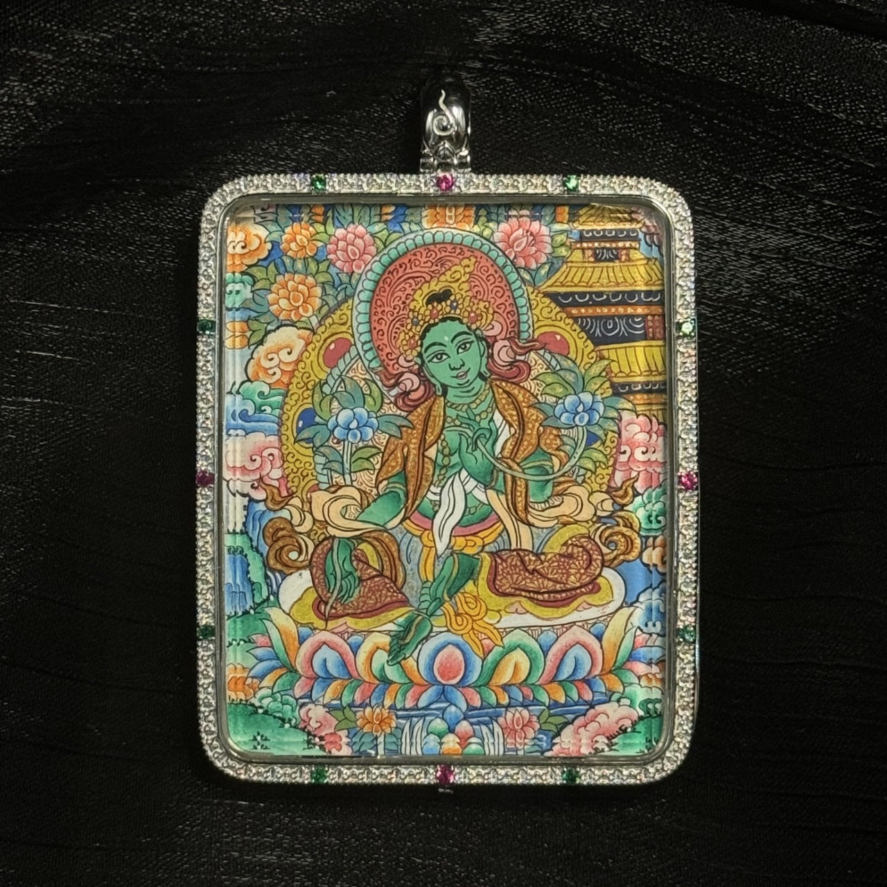 The Green Tara with Mandala Thangka pendant displayed as a sacred amulet for love, career and harmony, embodying Tibetan Buddhist tradition.

