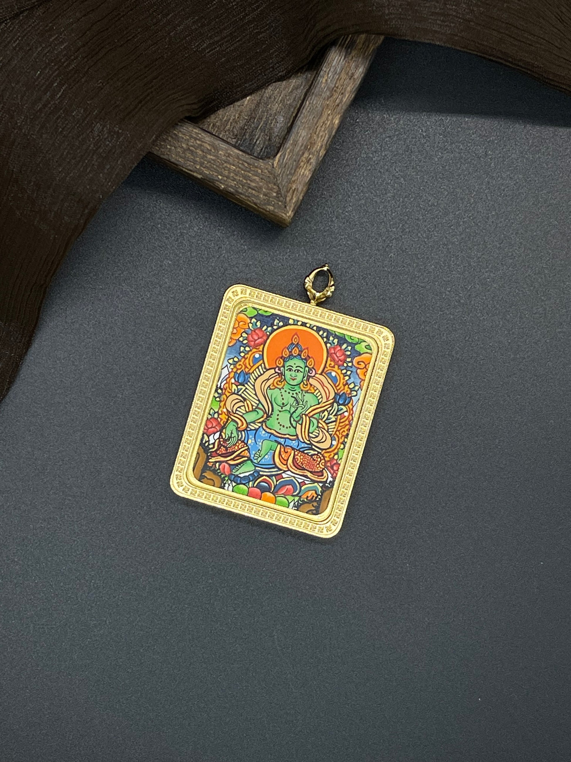 Hand-painted Nepal Green Tara (绿度母) Thangka pendant 3.5x4.5cm with titanium casing featuring the goddess of compassion, representing the removal of obstacles and auspiciousness in Buddhist tradition.
