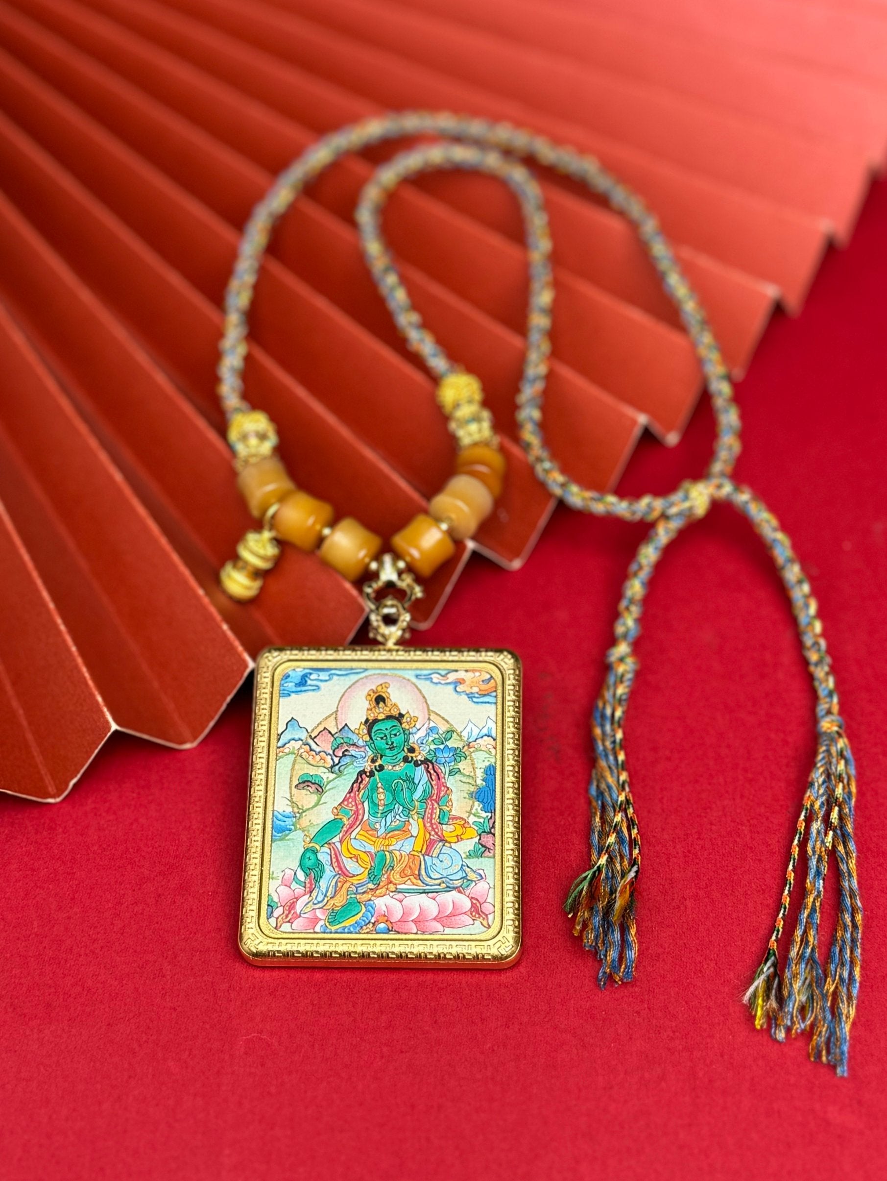 Hand-painted Nepal Green Tara (绿度母) Thangka pendant 4x5cm with titanium casing featuring the chief of twenty-one Taras, representing relief from suffering and fulfilment of wishes in Buddhist tradition.
