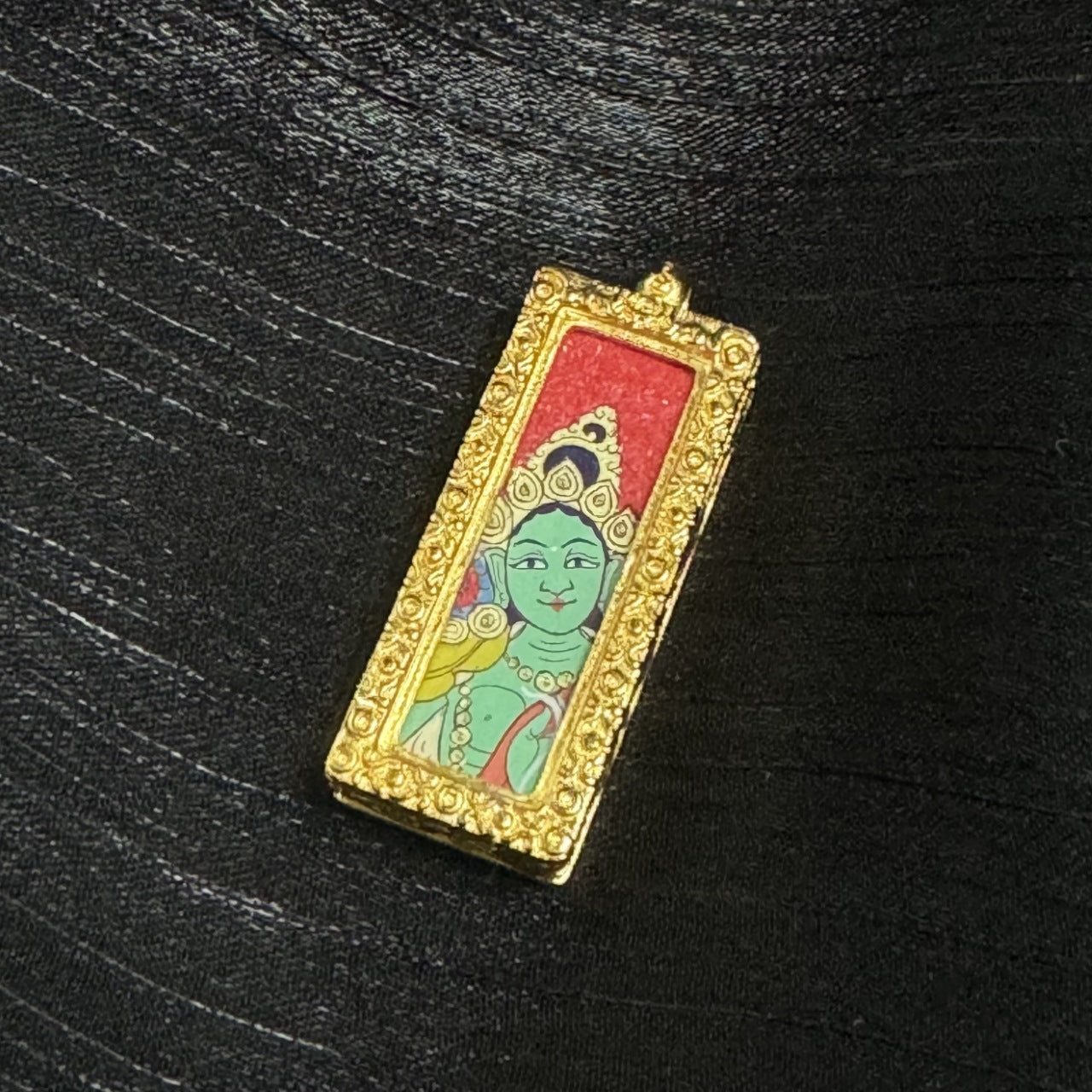  Detailed view of the copper casing for the Green Tara Thangka pendant, symbolizing protection and elegance in Tibetan Buddhist tradition.

