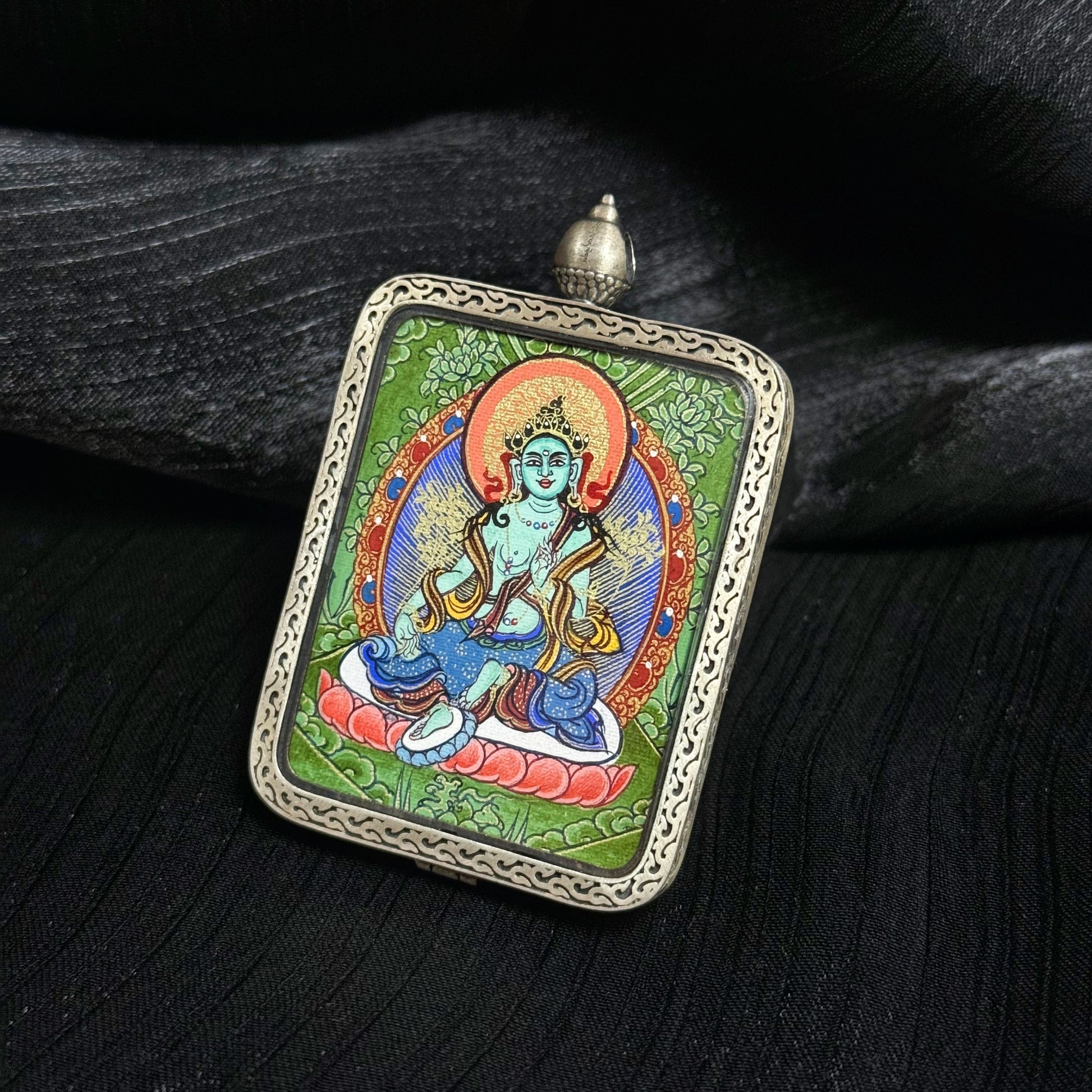 Detailed view of the presentation and casing for the Green Tara Cuiying Thangka pendant.

