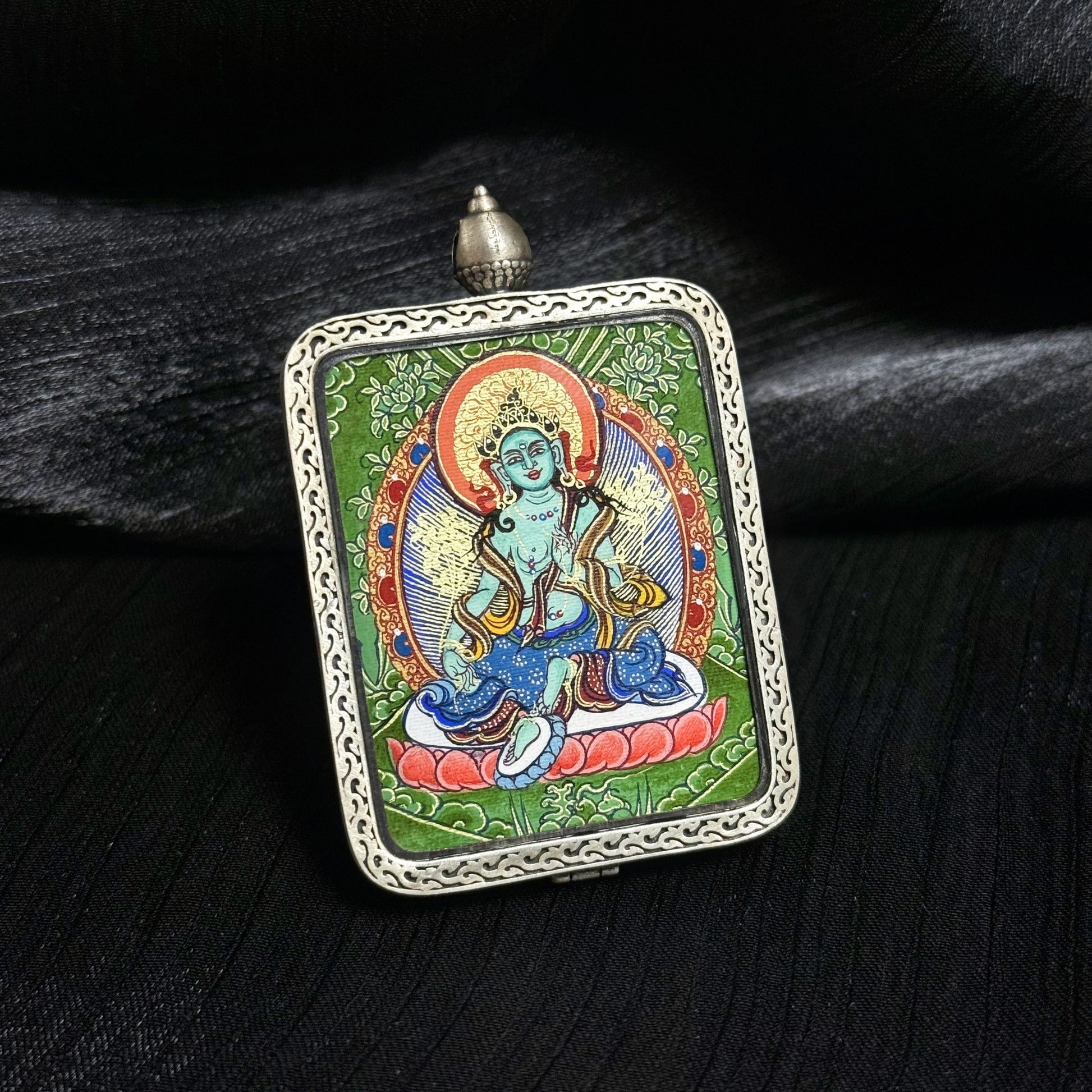 The Rekong Cuiying Green Tara Thangka pendant displayed as a sacred amulet for swift compassion and protection.
