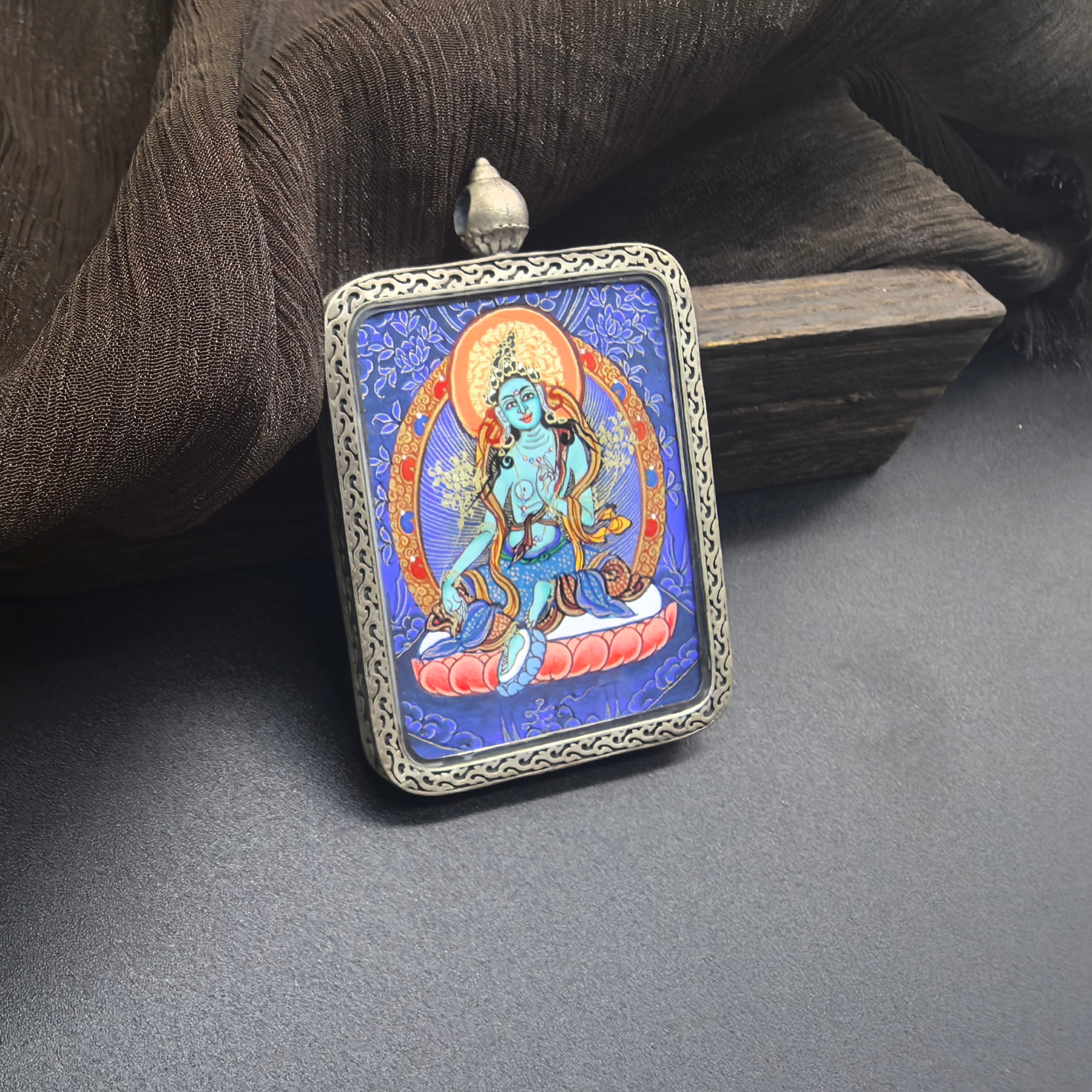 The Rekong Blue Thangka Green Tara pendant with 925 silver displayed as a sacred amulet for compassion and liberation, embodying Buddhist tradition.
