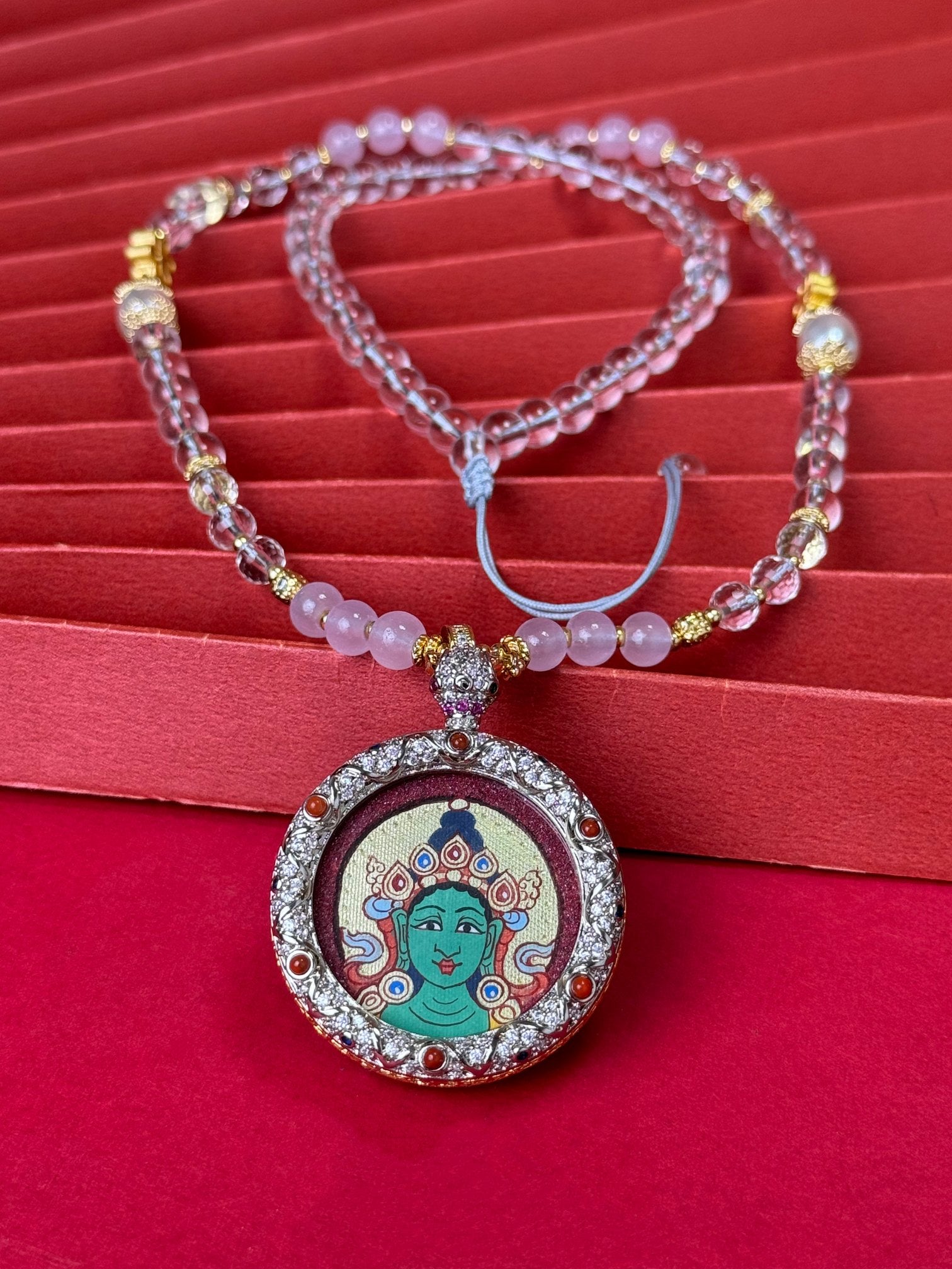 Hand-painted Rekong Red Gold Green Tara (绿度母) Thangka pendant 3.5cm with copper casing featuring the incarnation of Avalokiteshvara's tears, representing relieve suffering and all wishes fulfilled in Buddhist tradition.
