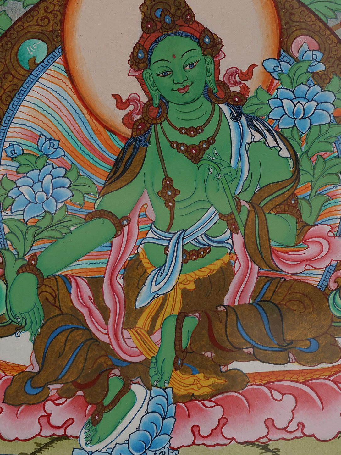 Alt text: Traditional Tibetan Thangka featuring Green Tara, symbolizing compassion and protection.