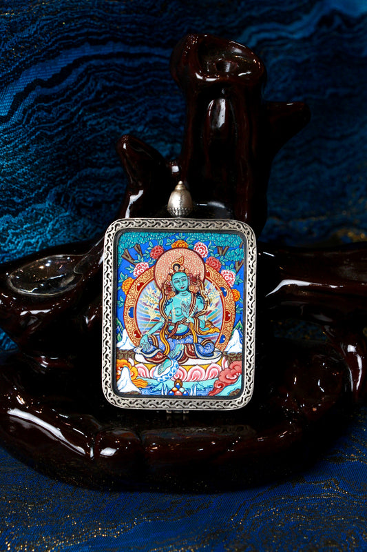 A sacred hand-painted Green Tara Thangka pendant from Regong, featuring the goddess of protection in a fine silver frame.