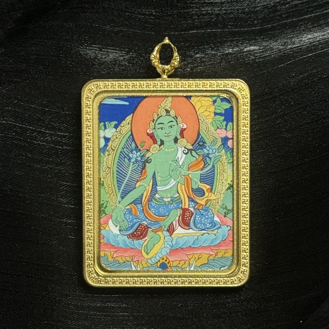 The Tibet Elegant Green Tara Thangka pendant displayed as a sacred amulet for compassion, love, and career success, embodying Tibetan Buddhist tradition.
