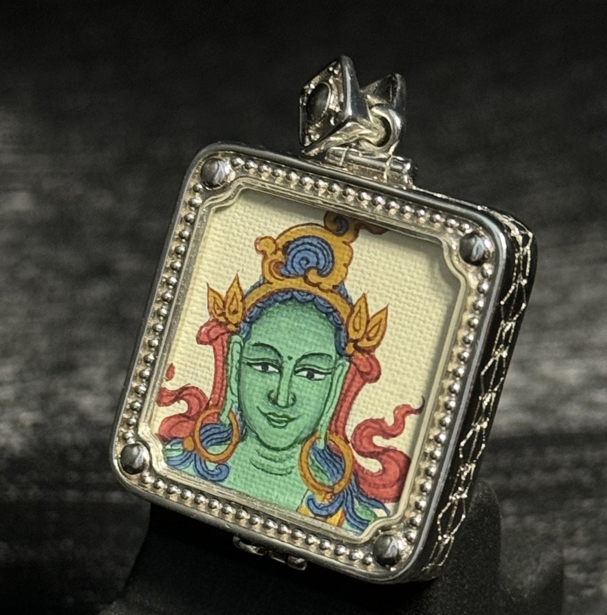  Detailed view of the protective casing for the Green Tara Thangka pendant, symbolising protection and tradition in Buddhist practice.
