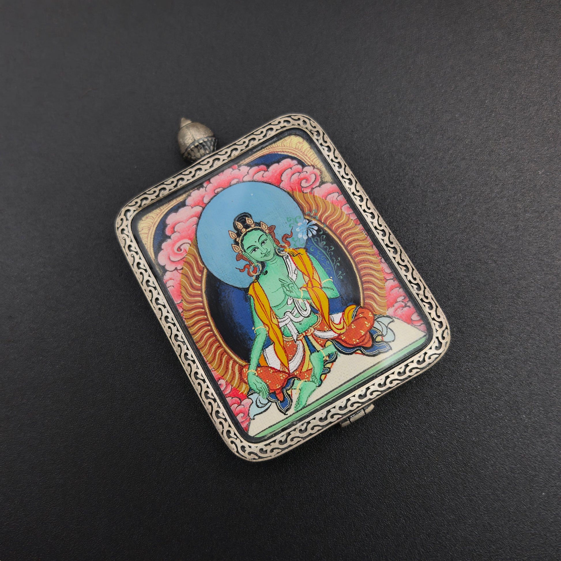 The Tibet Red Cloud Green Tara Thangka pendant with 925 silver displayed as a sacred amulet for compassion and liberation, embodying Buddhist tradition.
