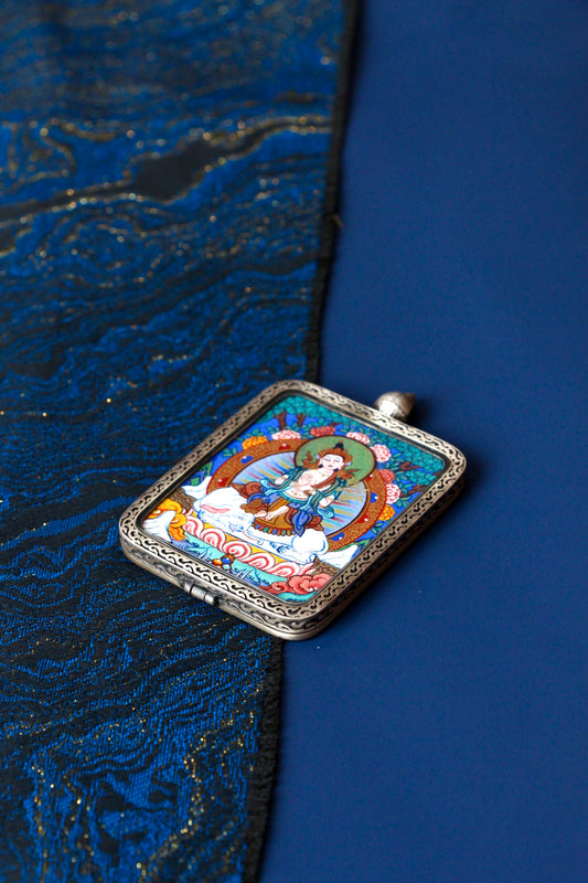 Macro view of a miniature Samantabhadra Thangka showing the intricate detailing of the white elephant mount and natural mineral colors used in Regong artistry.