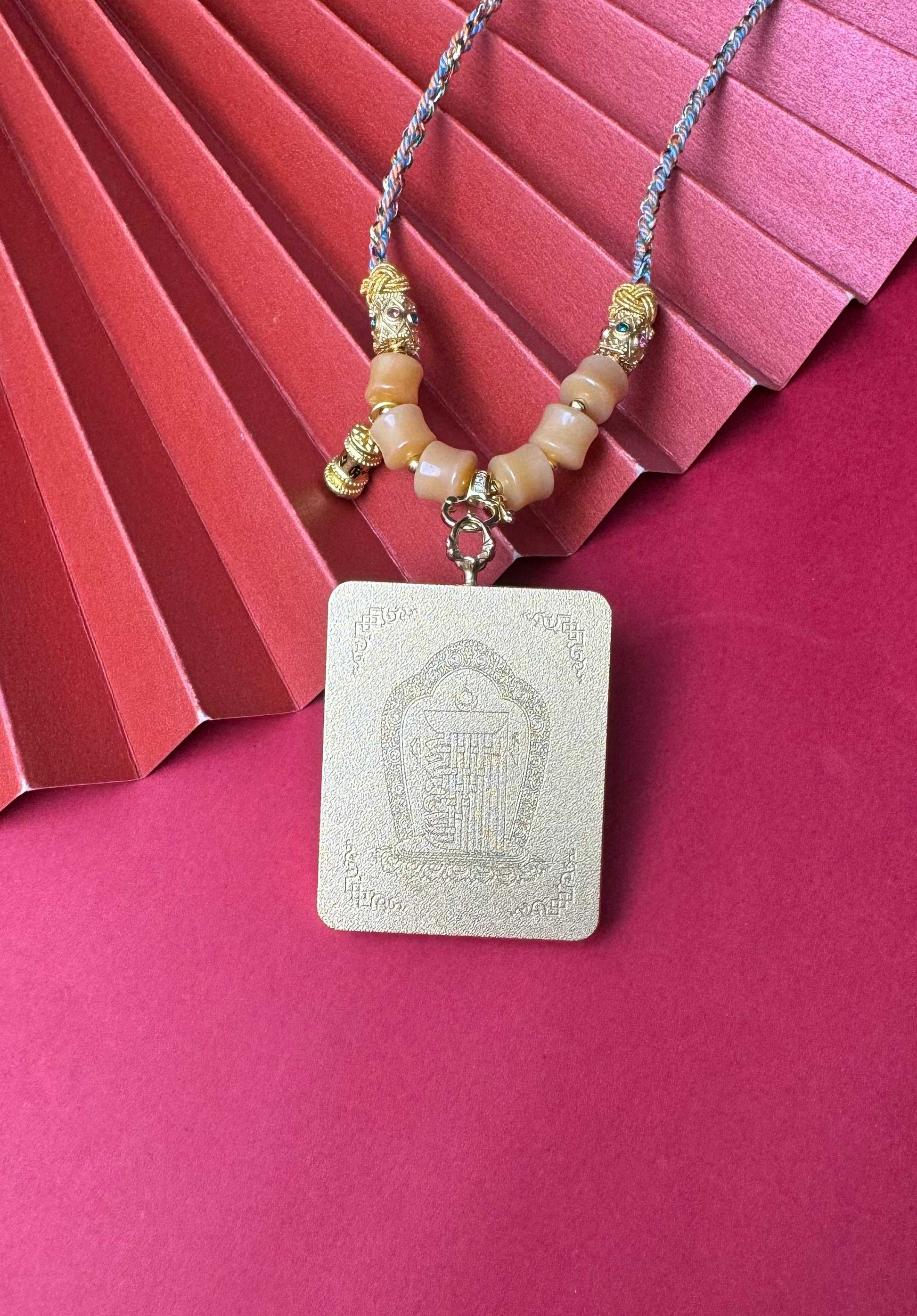  The Nepal Six-Armed Mahakala Thangka pendant with hand-designed cord displayed as a sacred amulet for abundant life and prosperous wealth, embodying Buddhist tradition.
