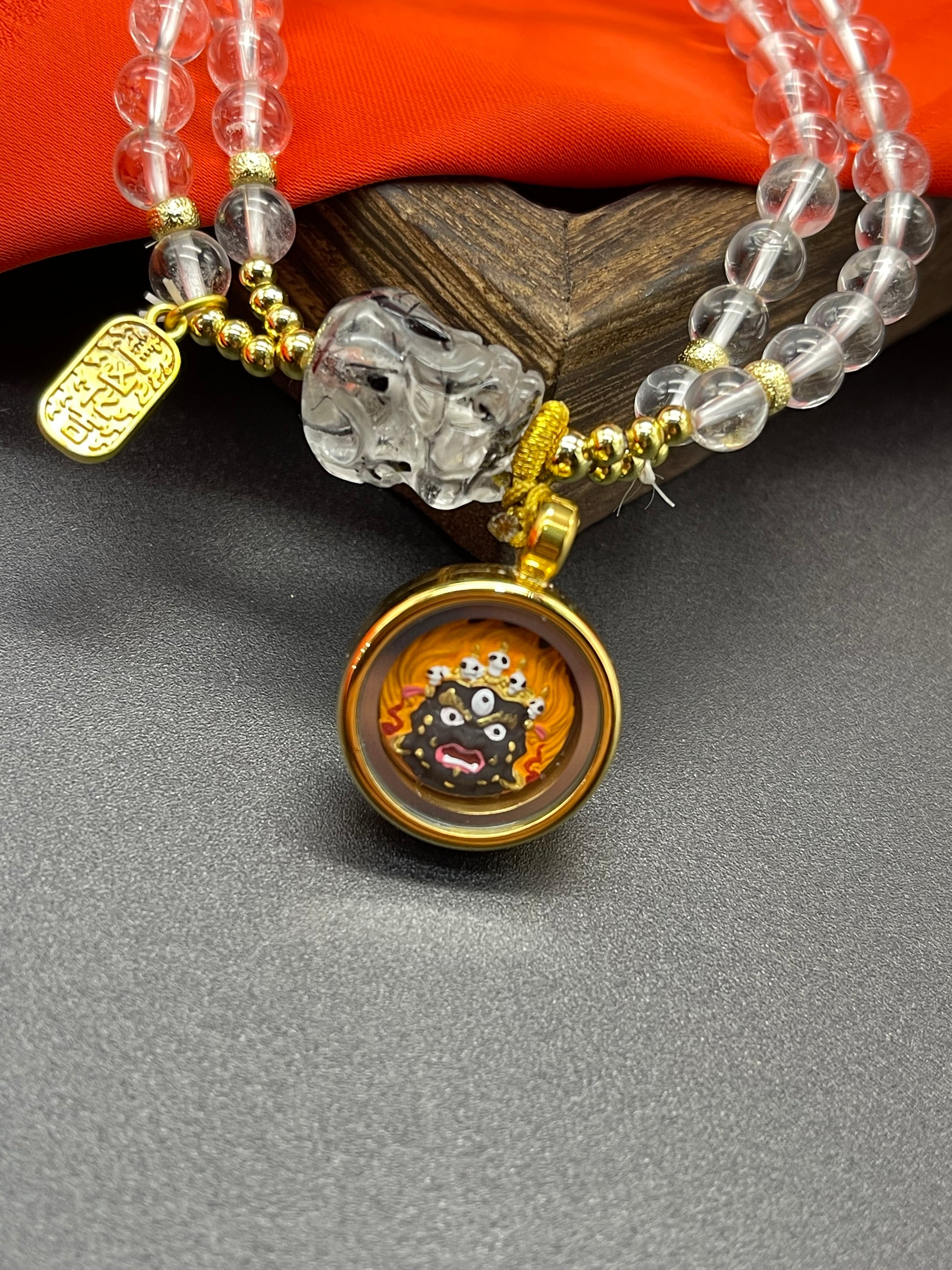 The Mahakala Painted Tsa-Tsa with white quartz pixiu bracelet displayed as a sacred amulet for warding off evil and the increase of merit and wisdom, embodying Buddhist tradition.
