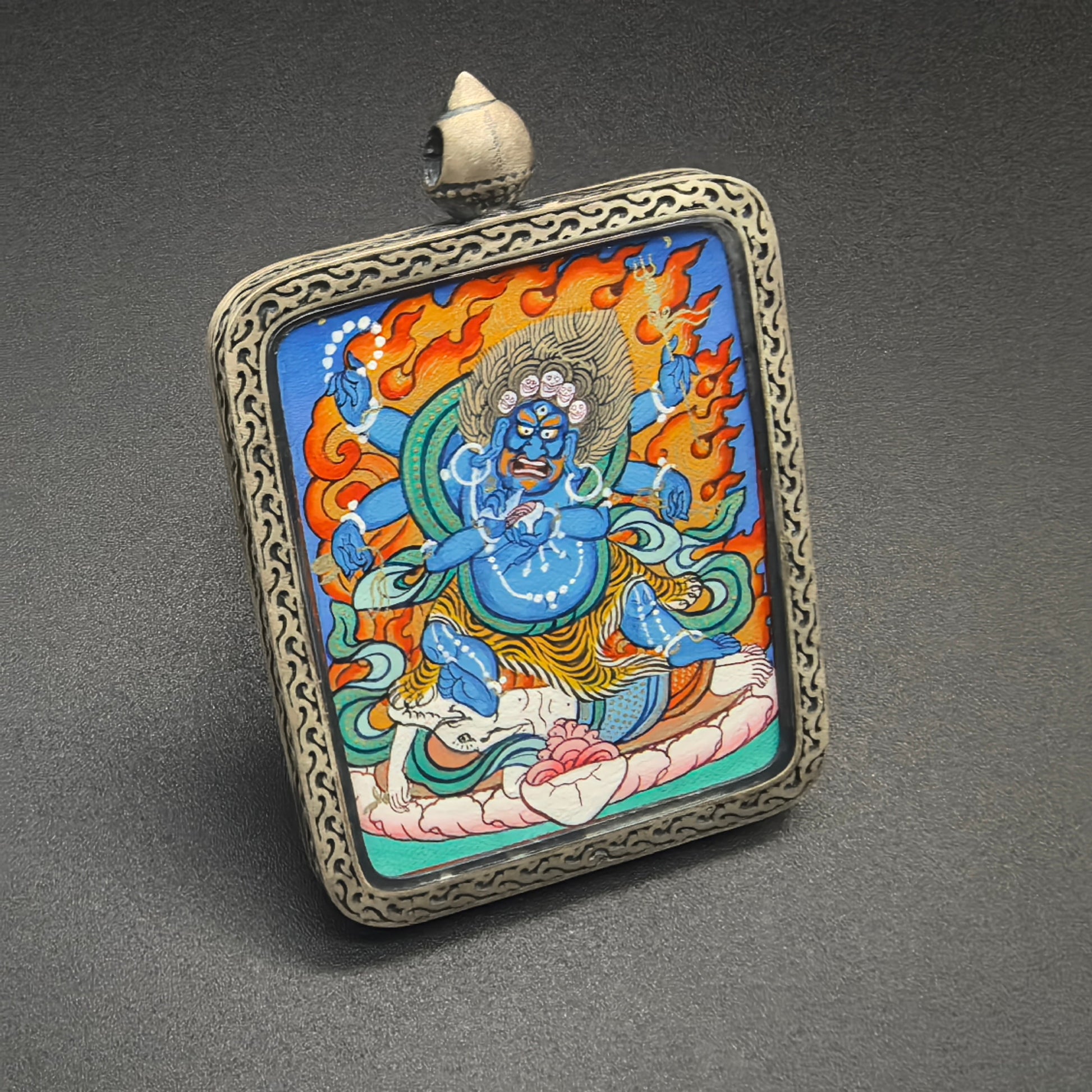 A 4x5cm hand-painted Rekong Mahakala (大黑天) Thangka pendant with 925 silver casing featuring the great protector, representing protection and fortune in Buddhist tradition.
