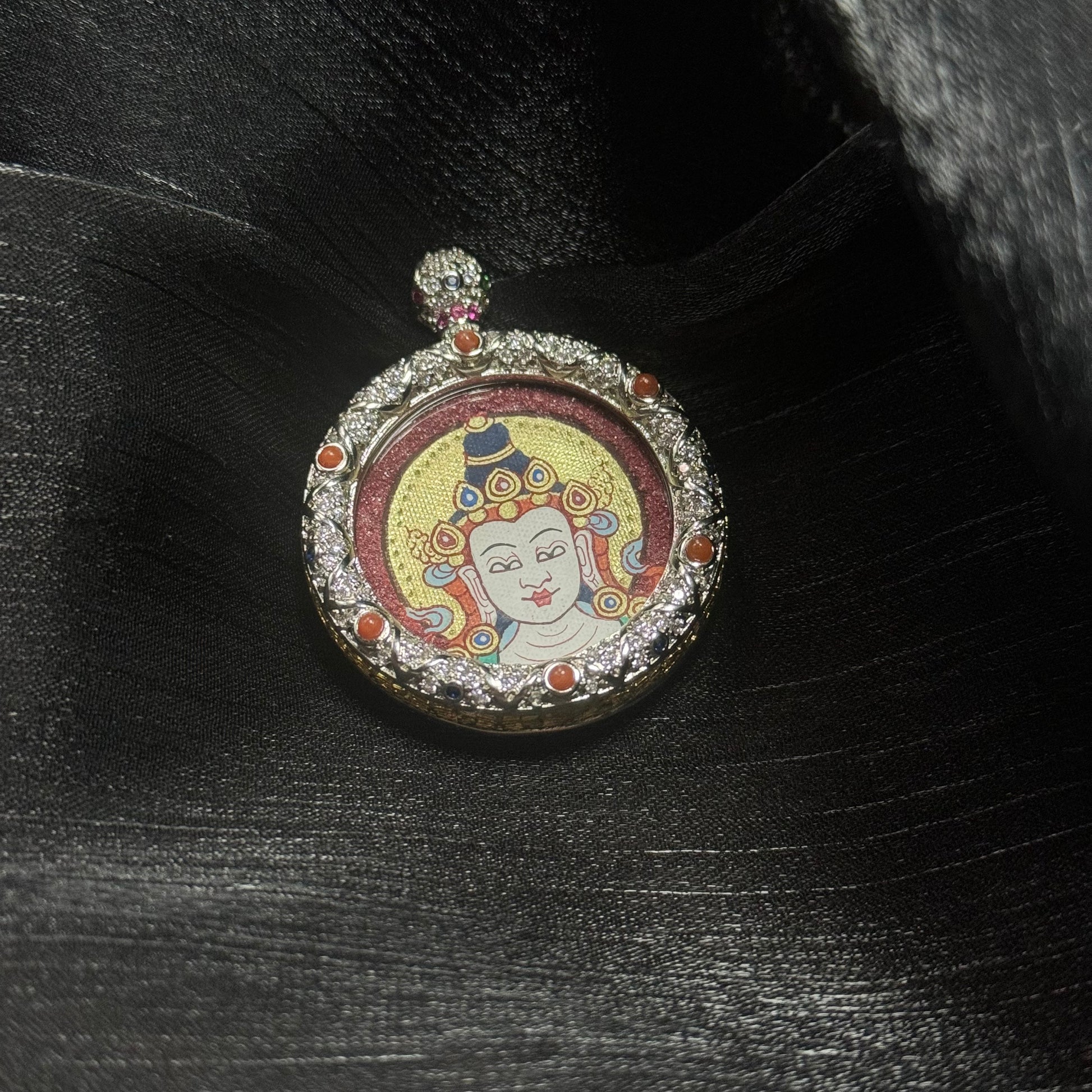  The Rekong Red-Gold Mahasthamaprapta Buddha Head Thangka pendant displayed as a sacred amulet for joyful giving and wealth, embodying Buddhist tradition.
