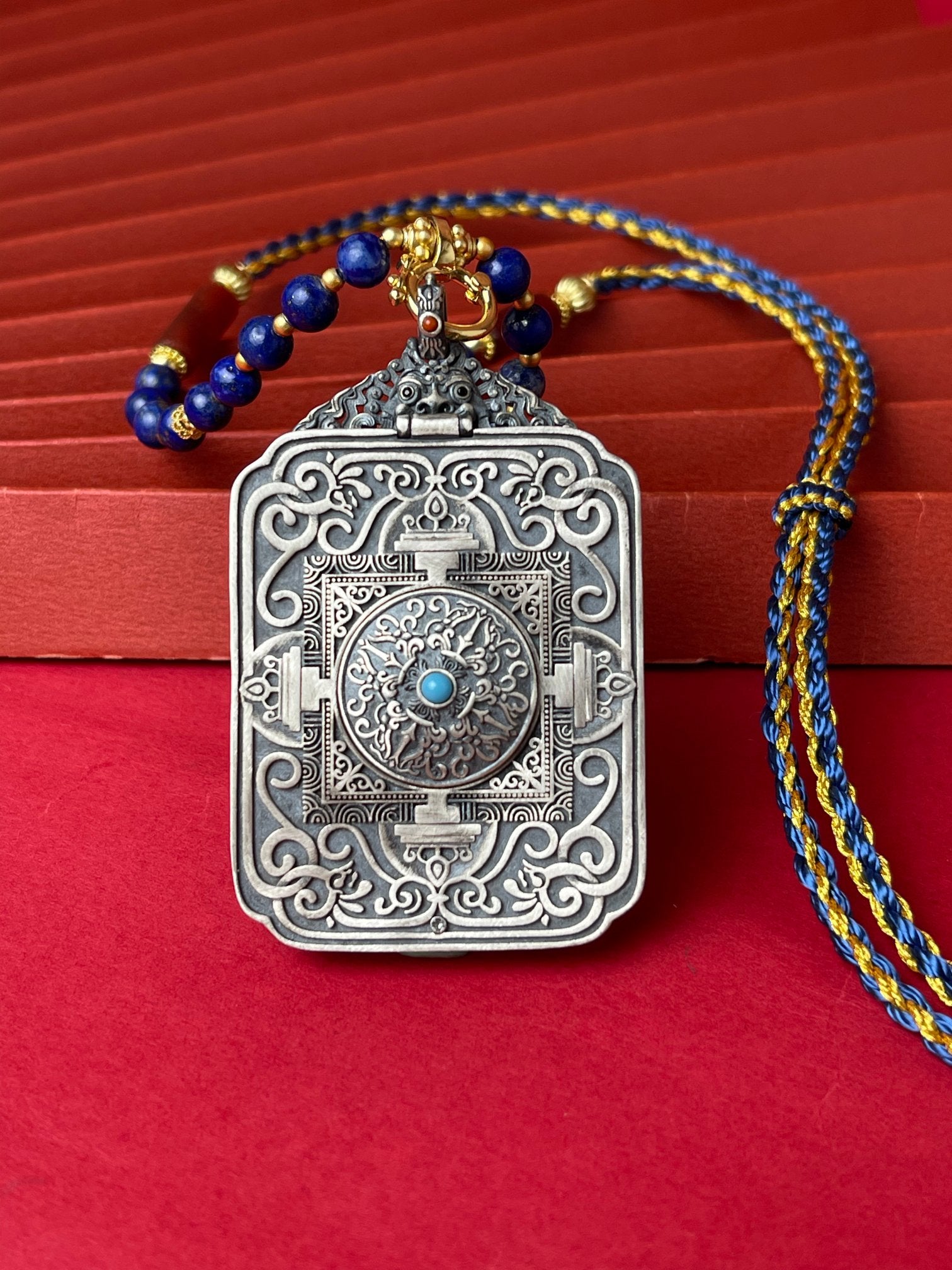  The Tibet Mahasthamaprapta Thangka pendant with refined silver casing and hand-woven cord displayed as a sacred amulet for light and wisdom, embodying Buddhist tradition.

