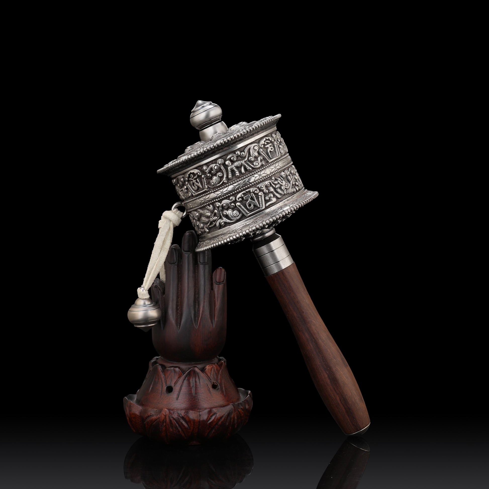 Detailed view of a Tibetan Buddhist prayer wheel with sacred symbols and gold decorations