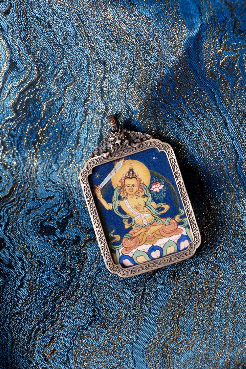 Manjushri Bodhisattva thangka pendant depicting the Tibetan Buddhist deity of wisdom, symbolizing insight, knowledge, and enlightened guidance.