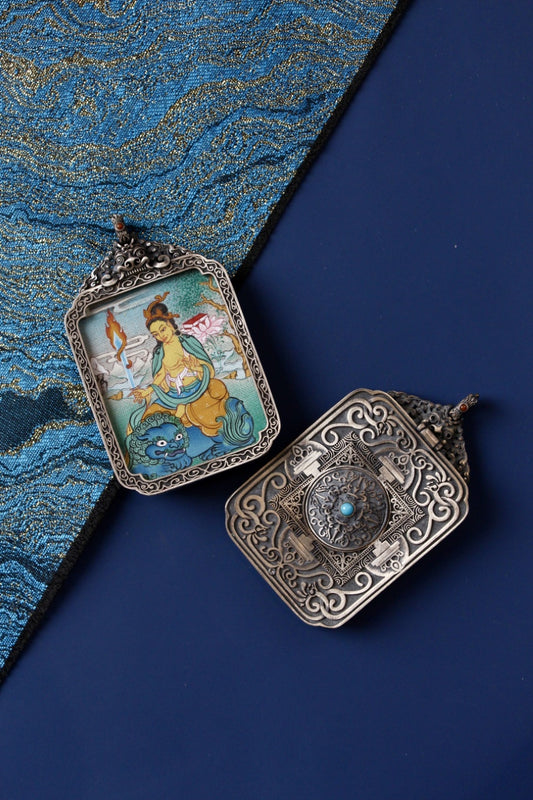 Tibetan Buddhist thangka pendant depicting Manjushri Bodhisattva holding the sword of wisdom, symbolizing insight and enlightenment.