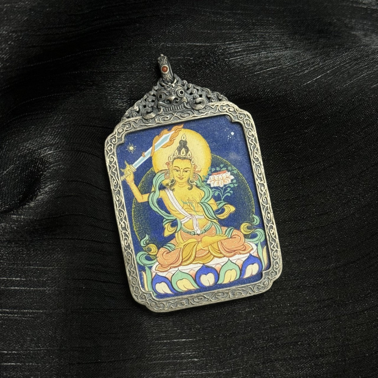  A 3.5x4.5cm hand-painted Bold-style Manjushri Bodhisattva Thangka pendant featuring the deity of wisdom, encased in antique silver-tone metal, symbolising discernment and success in Tibetan Buddhist tradition.

