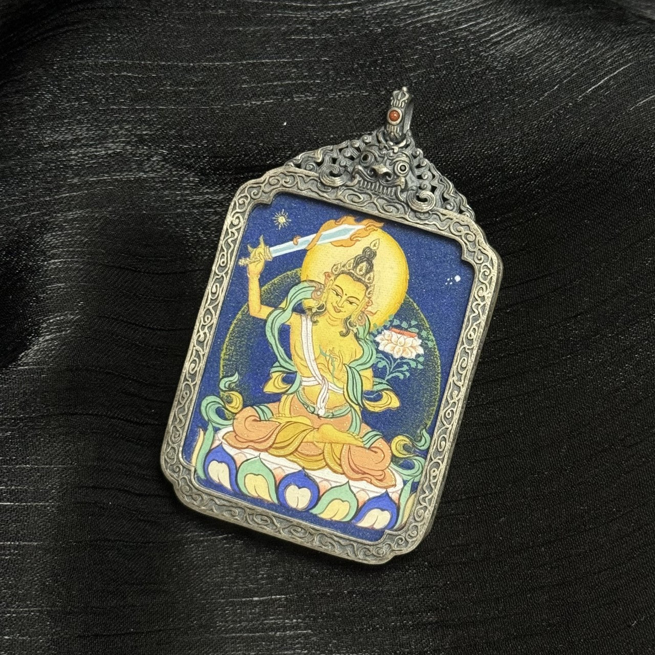  Close-up detail of the Bold Manjushri Thangka painting showing intricate natural mineral pigment work and symbolic attributes, showcasing the artistry of Tibetan lineage painters.
