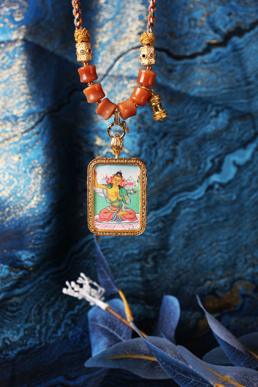 The Karma Kagyu Manjushri Thangka pendant displayed as a sacred amulet for wisdom and learning, embodying the sword of wisdom of Tibetan Buddhist tradition.

