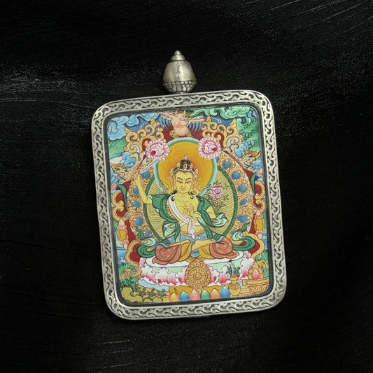  The Menri Manjushri Thangka pendant displayed as a sacred amulet for wisdom and success, embodying the wisdom of Tibetan Buddhist tradition.
