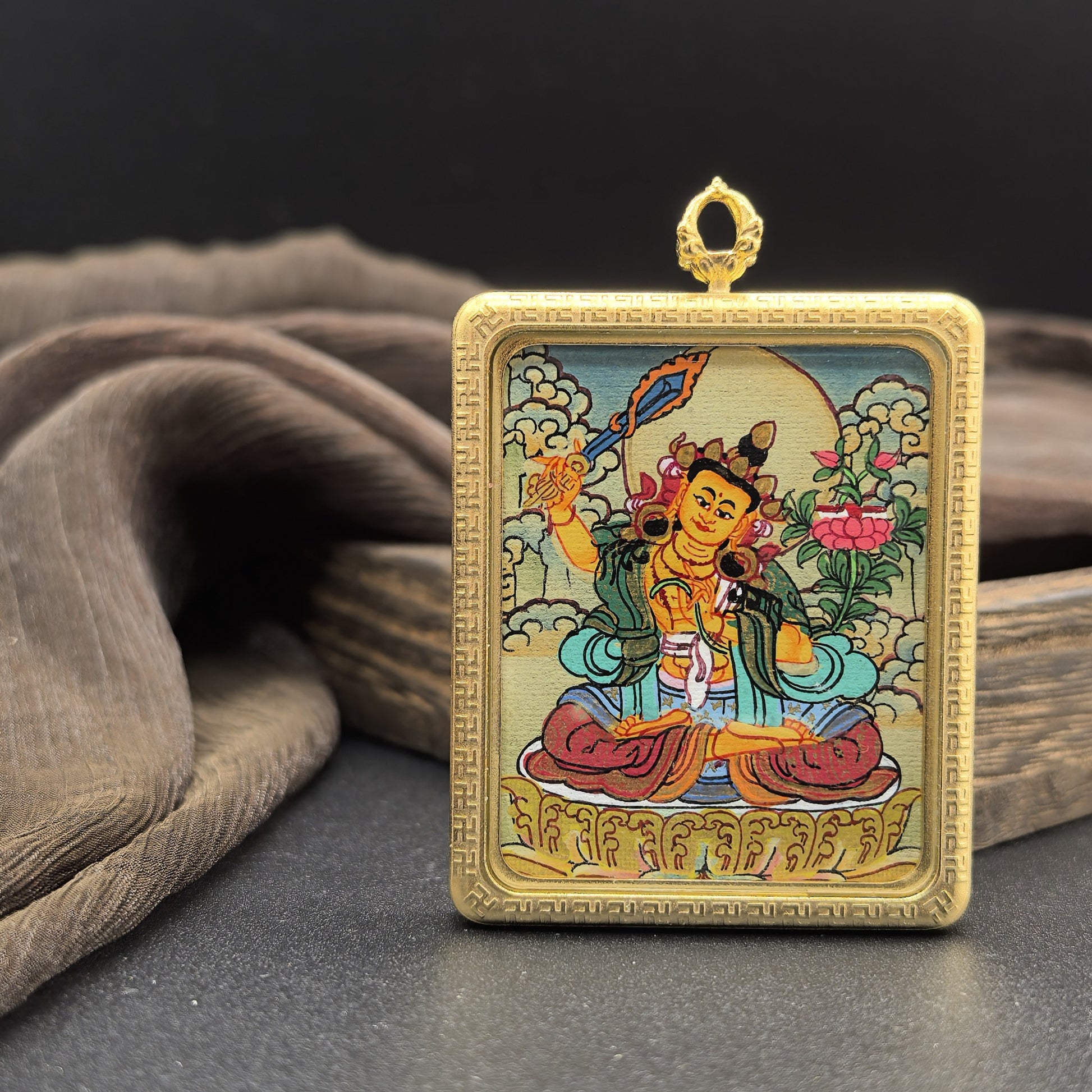  Detailed view of the titanium casing for the Manjushri Thangka pendant, symbolising wisdom and tradition in Buddhist practice.
