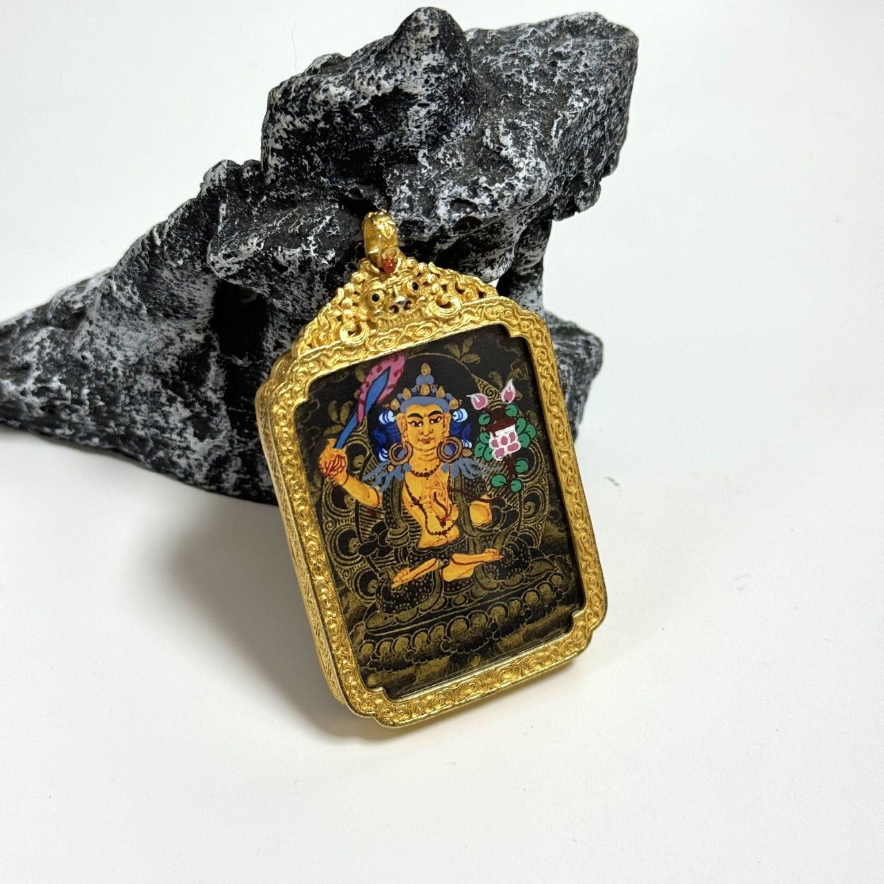 The Nepal Black Gold Manjushri Thangka pendant displayed as a sacred amulet for wisdom and merit, embodying Tibetan Buddhist tradition.
