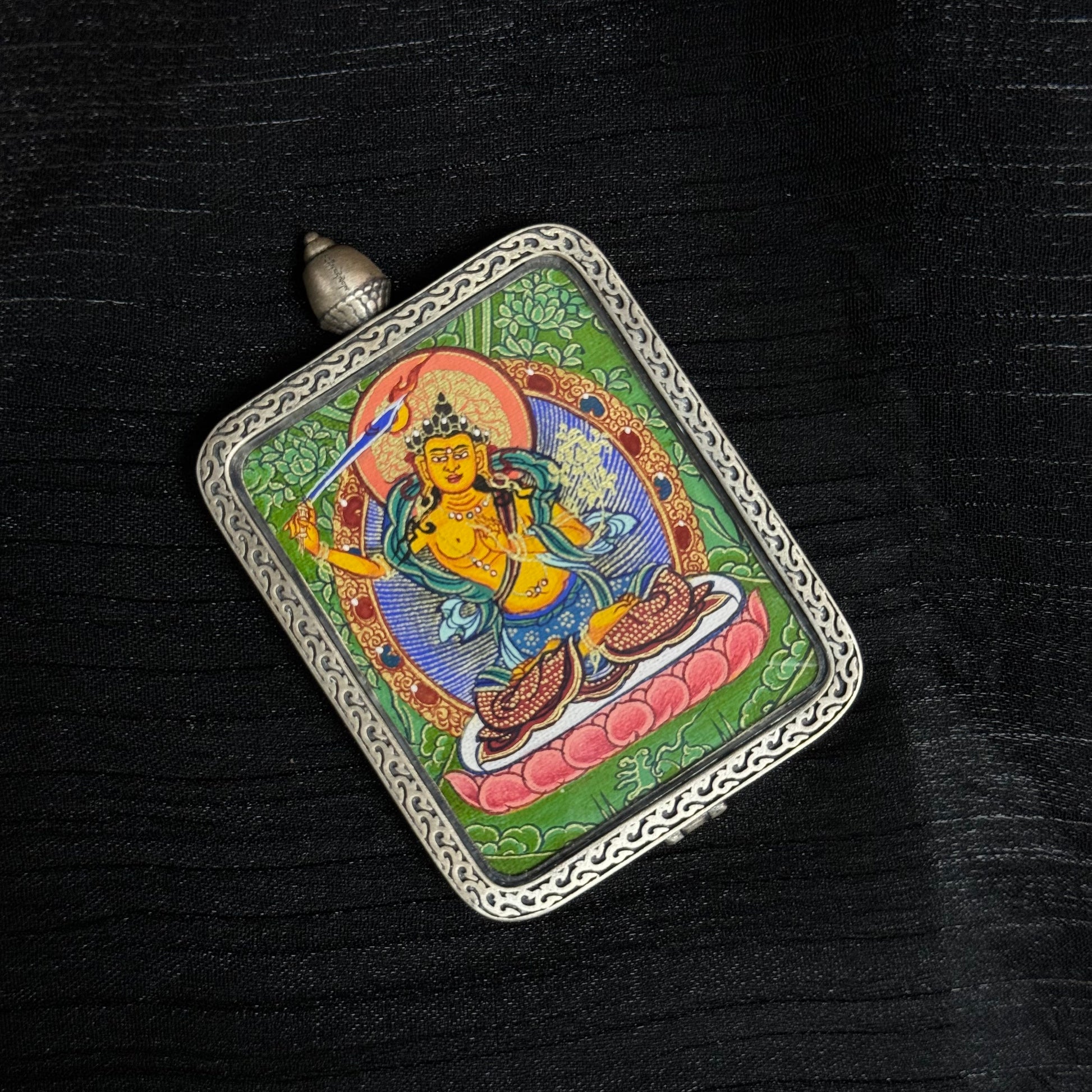  The Rekong Cuiying Manjushri Thangka pendant displayed as a sacred amulet for wisdom and study, embodying Buddhist tradition.
