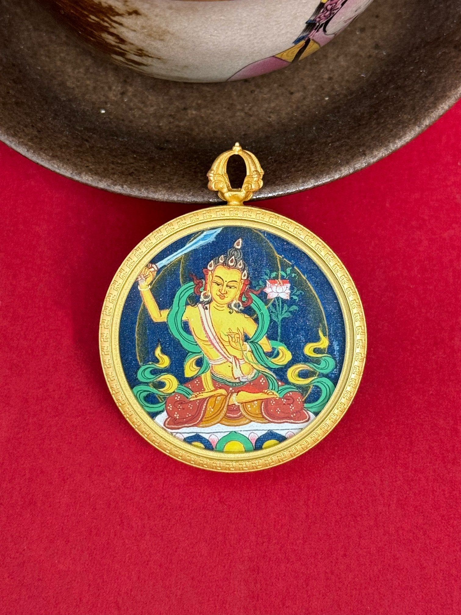 Close-up detail of the Tibet Bold Manjushri Thangka showing hand-painted mineral pigments, gold and lapis, showcasing the masterful artistry and three-dimensional imagery.

