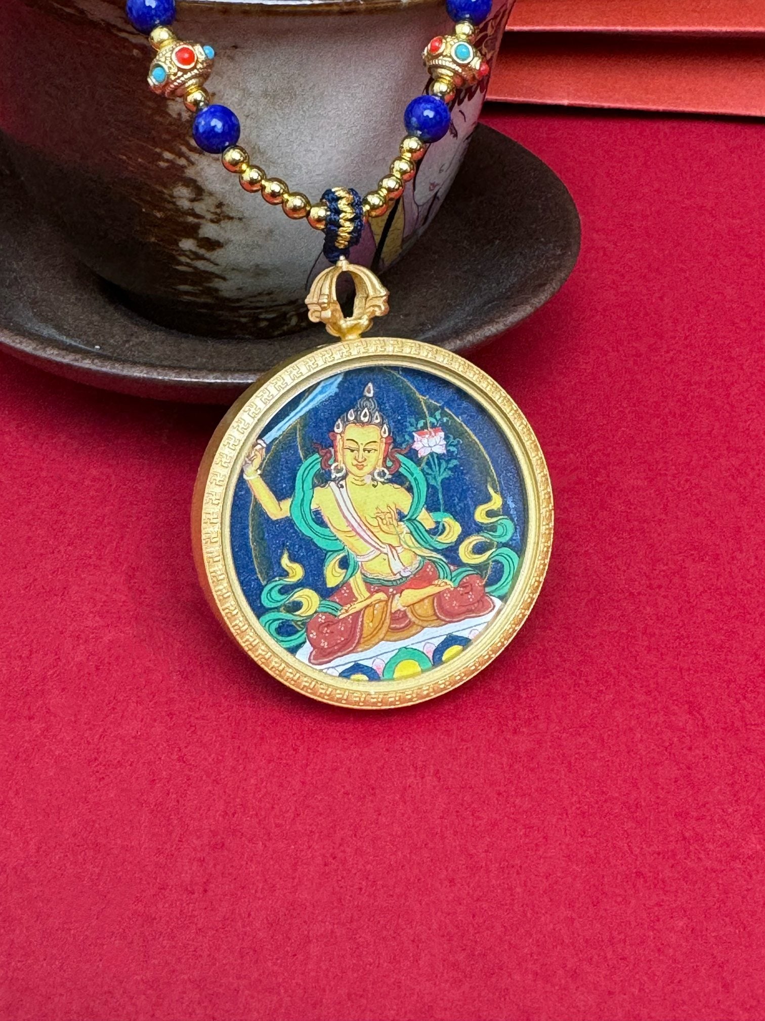  Detailed view of the refined copper casing for the Manjushri Thangka pendant, symbolising wisdom and tradition in Buddhist practice.
