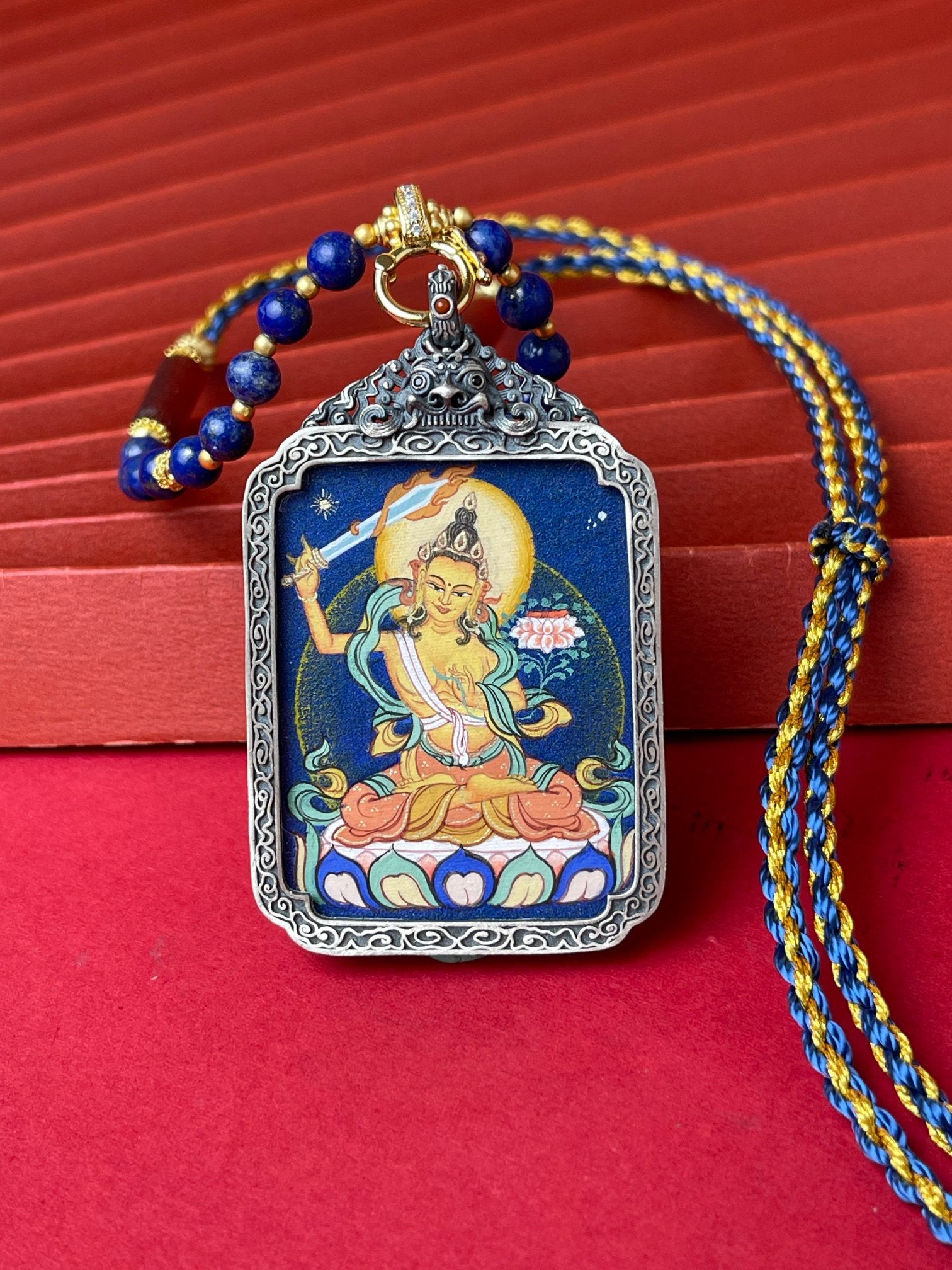  Detailed view of the refined silver casing for the Manjushri Thangka pendant, symbolising wisdom and tradition in Buddhist practice.
