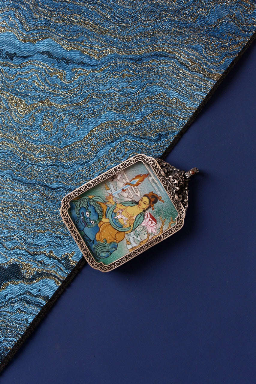 Sacred Tibetan thangka pendant of Manjushri Bodhisattva, associated with Himalayan wisdom and spiritual awakening.