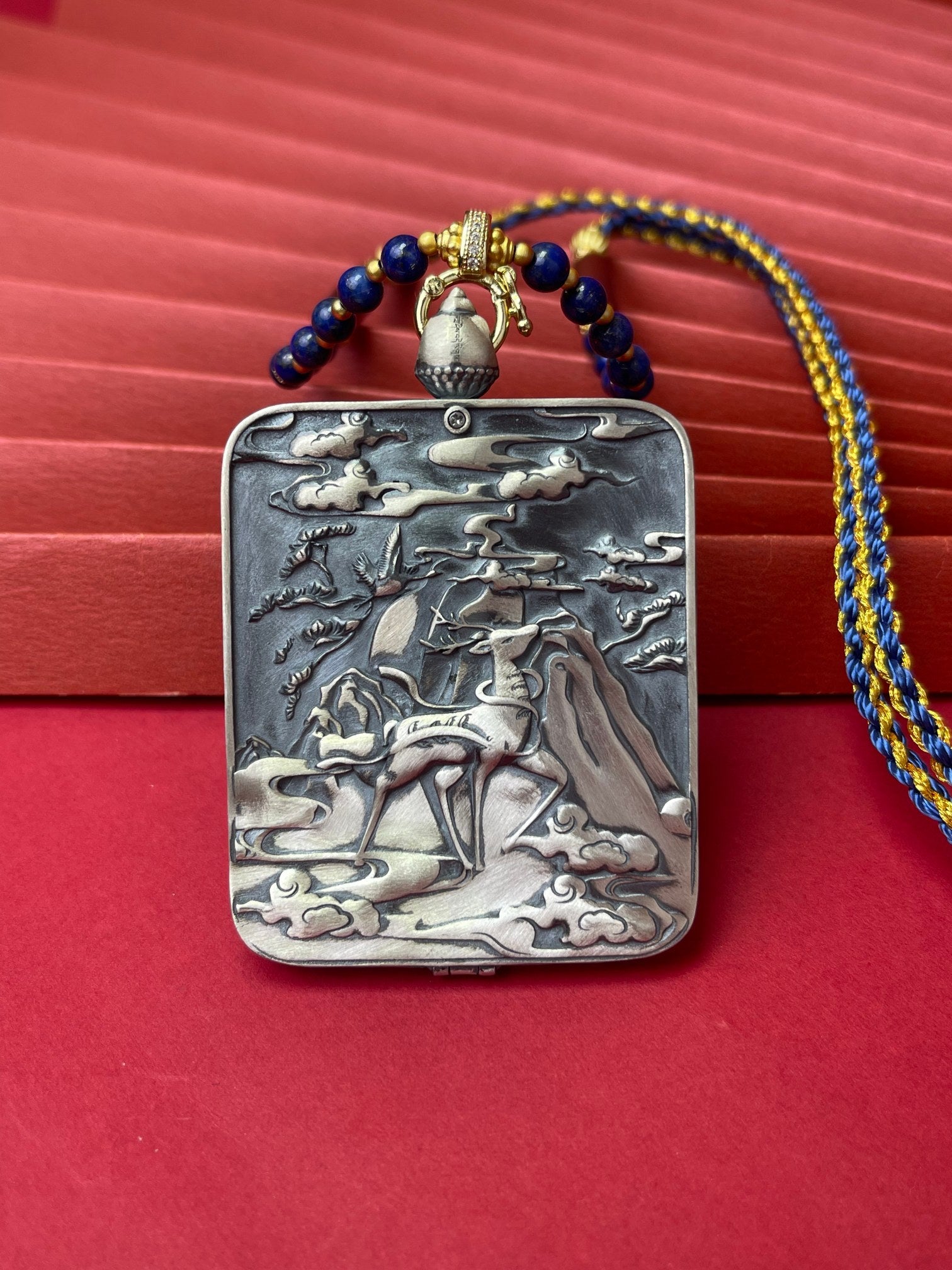  The Rekong Marici Thangka pendant with Dunhuang Nine-Colour Deer silver casing displayed as a sacred amulet for dispelling disaster and great freedom, embodying Buddhist tradition.

