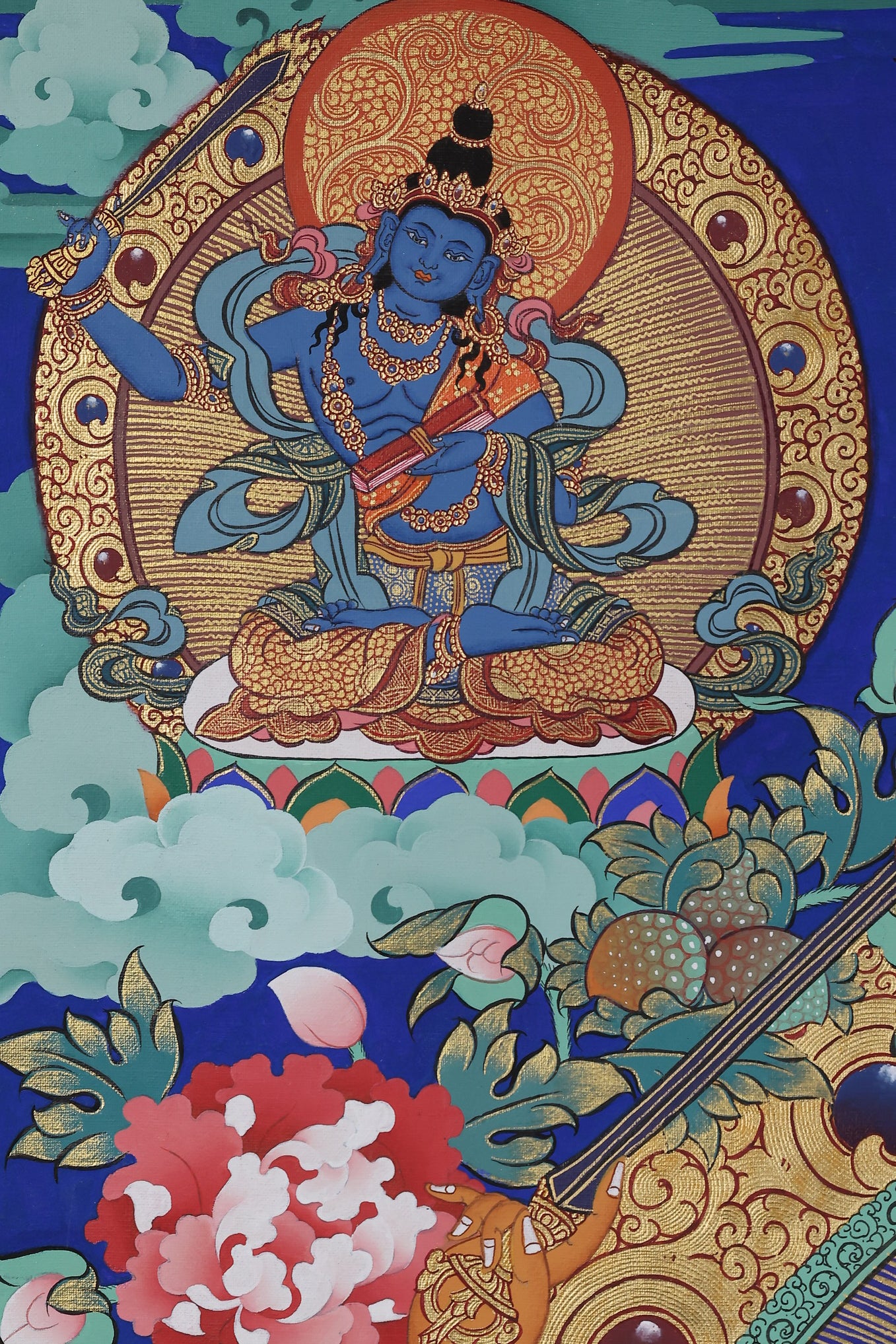 Alt Text: Iconic form of Manjushri Bodhisattva in a vibrant Tibetan Thangka, holding sword and sutra.