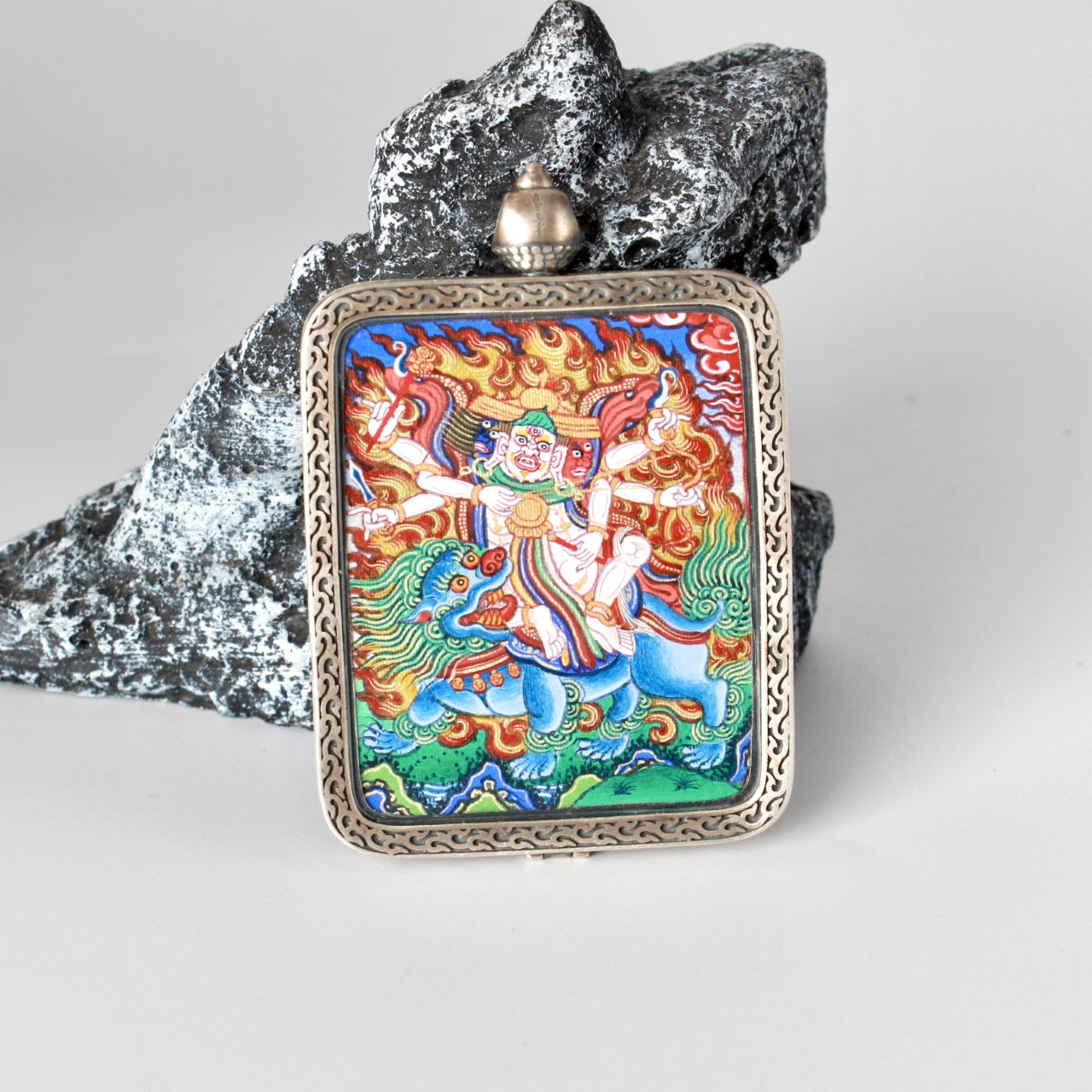 Hand-painted Rebgong Pehar Thangka pendant featuring the Dharma protector and oracle deity, encased in Dunhuang Nine-Colour Deer silver, representing protection and success in Tibetan Buddhist tradition.

