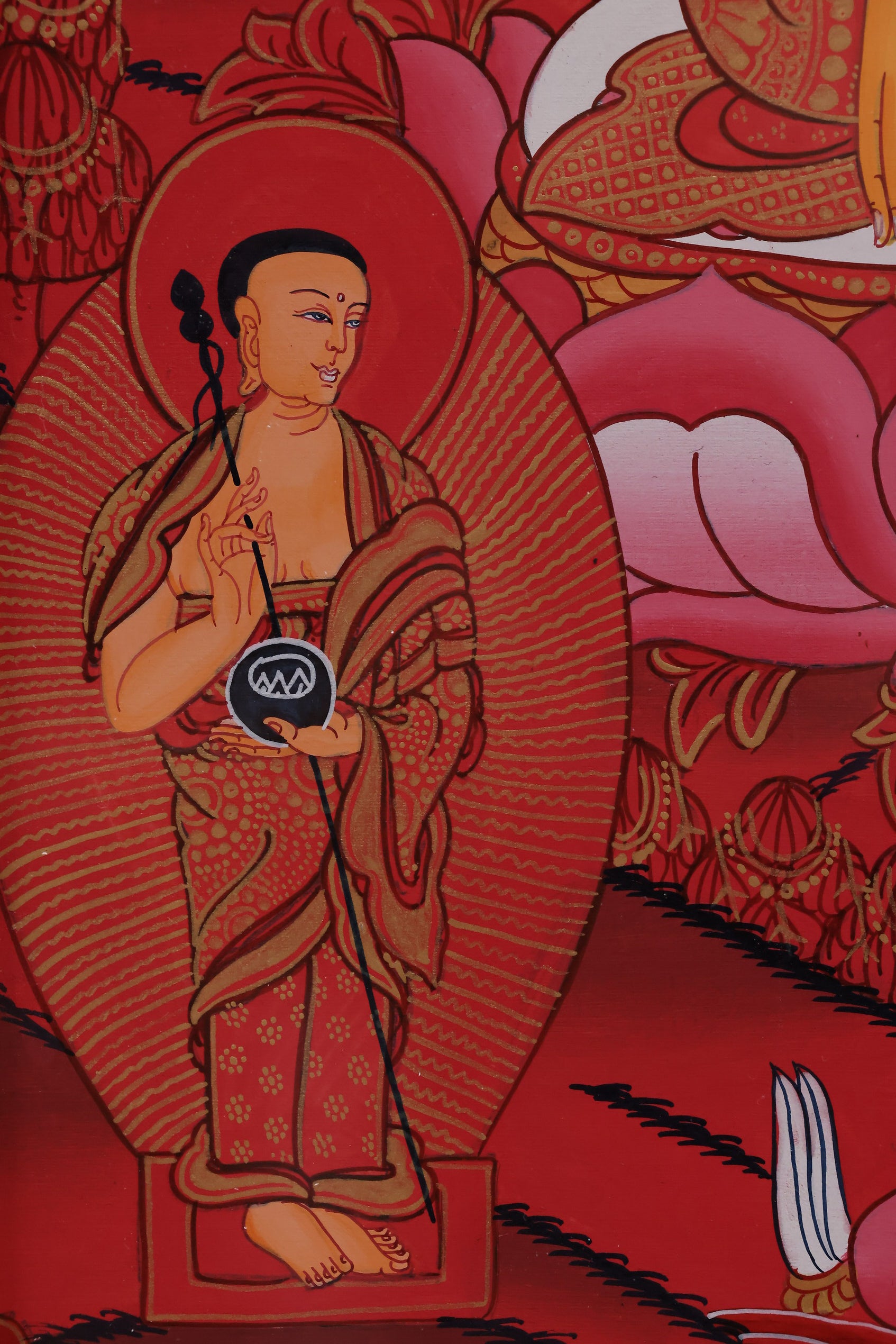 Red Shakyamuni Buddha with hand mudras, representing compassion and wisdom in Tibetan Buddhism.