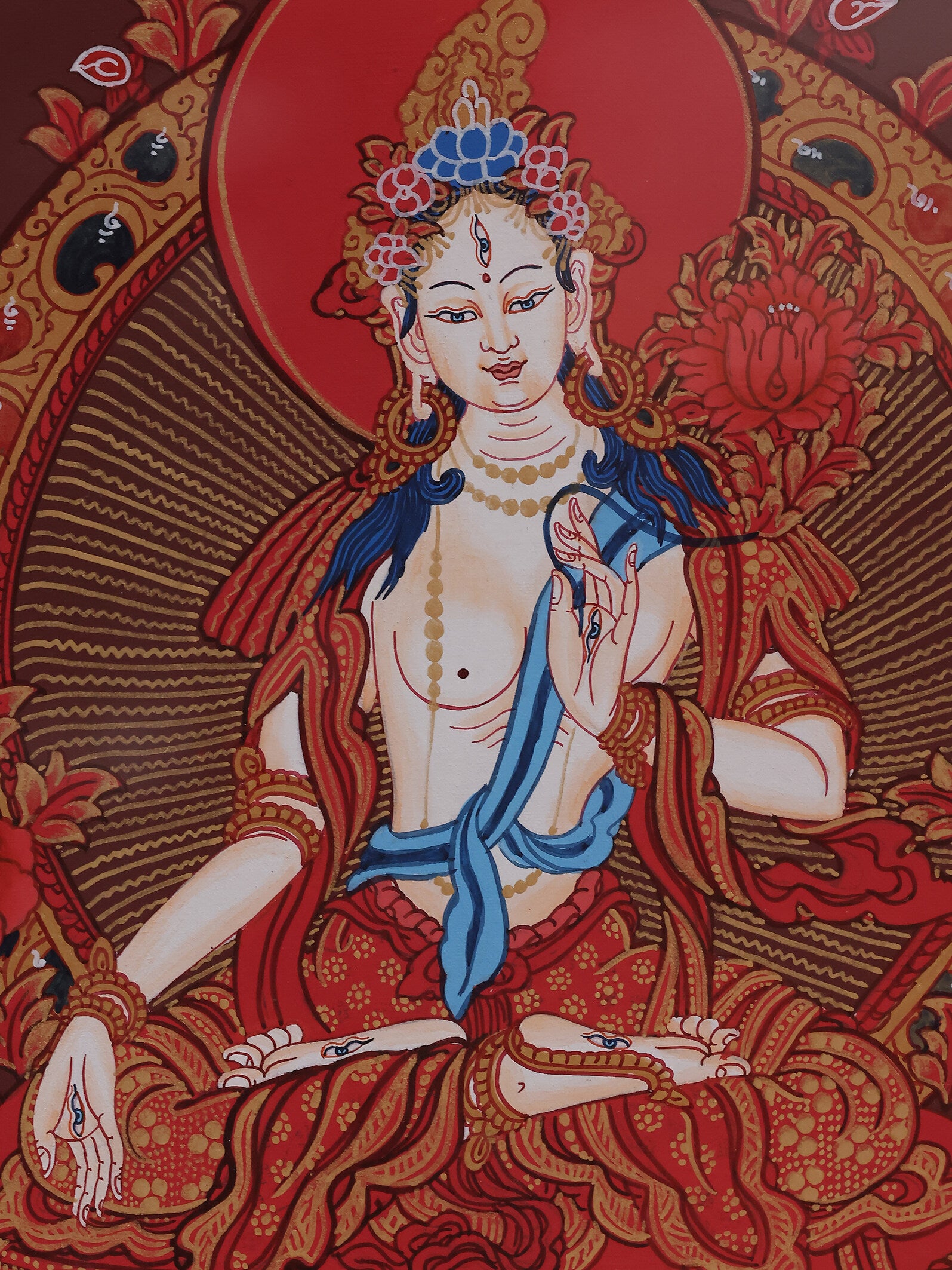 White Tara depicted on a red background thangka, representing compassion and spiritual blessings in Tibetan Buddhism