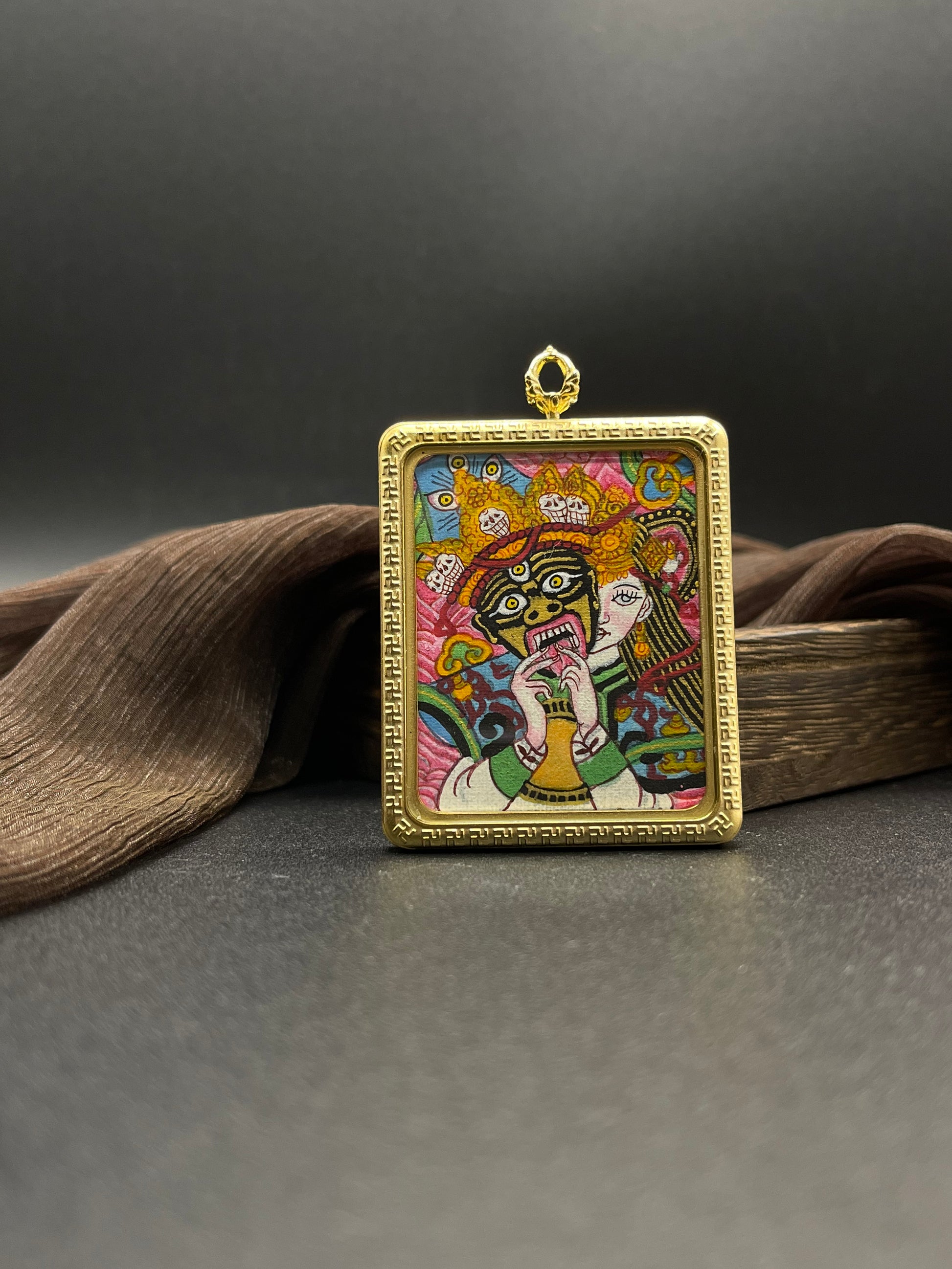 Detailed view of the titanium casing for the Shachilama Pink Past and Present Thangka pendant, symbolising unyielding courage and tradition in Buddhist practice.


