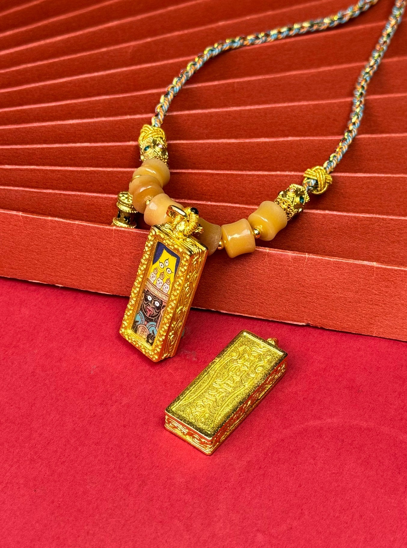 The Rekong Shachilama Thangka pendant with copper casing displayed as a sacred amulet for protect and bless the world, embodying Buddhist tradition.

